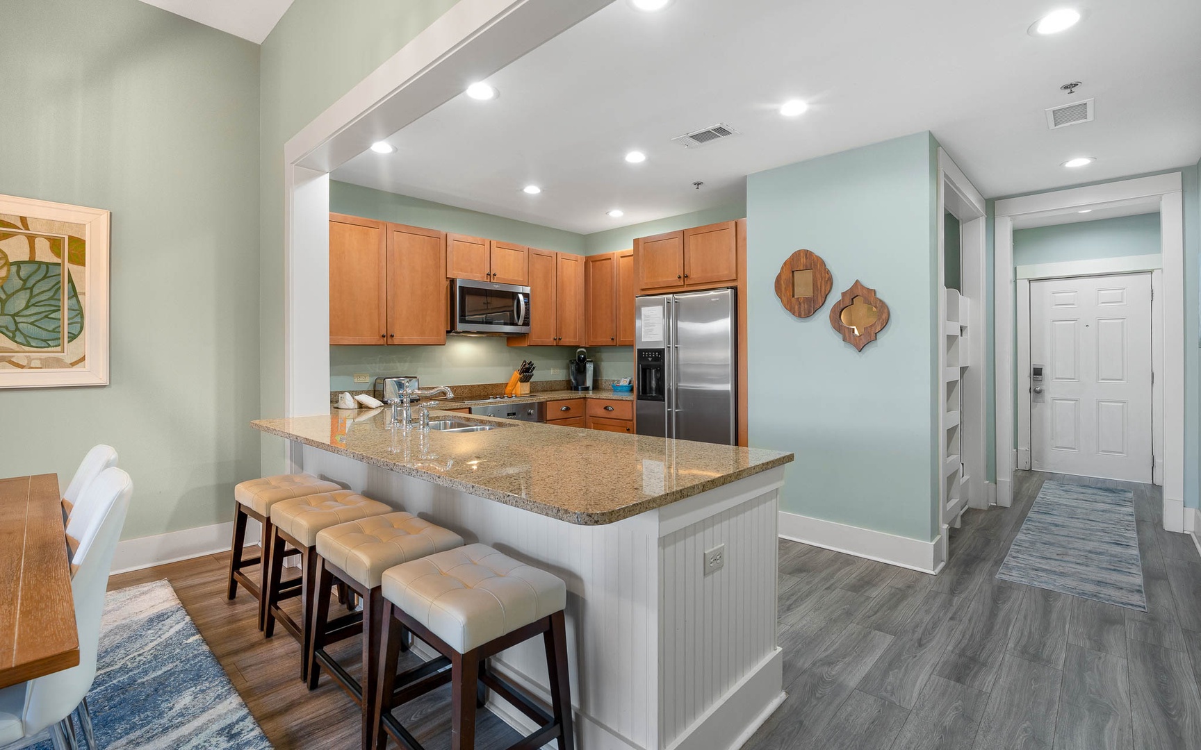 Your open-concept kitchen flows seamlessly into the living space, featuring granite countertops, stainless appliances, and a breakfast bar perfect for morning coffee.