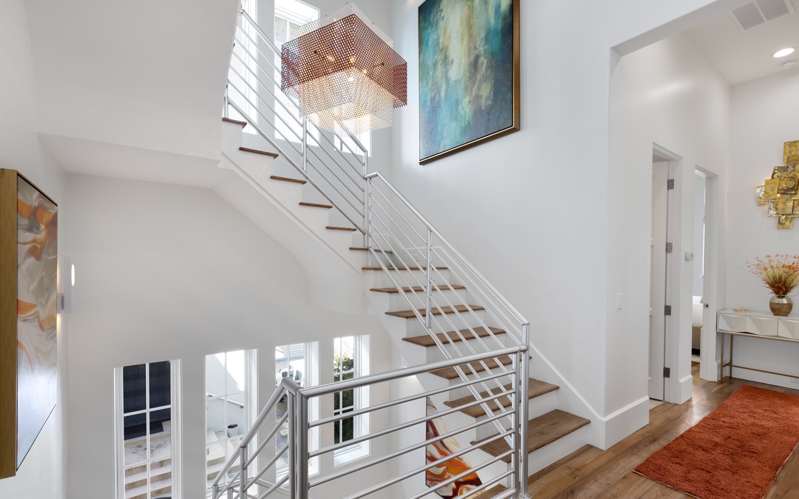 Step into your modern sanctuary where sleek stairs lead to private retreats, warm wood meets contemporary art, and natural light dances through every corner.