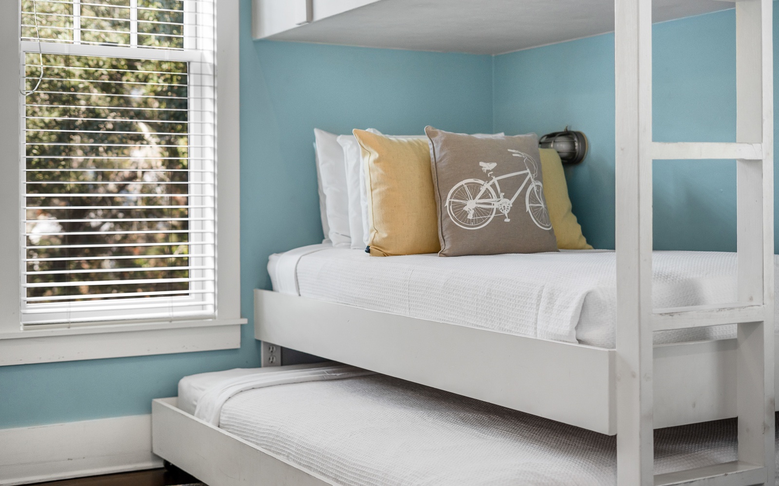 Relax in your serene space with cheerful accents and natural light filtering through stylish blinds.