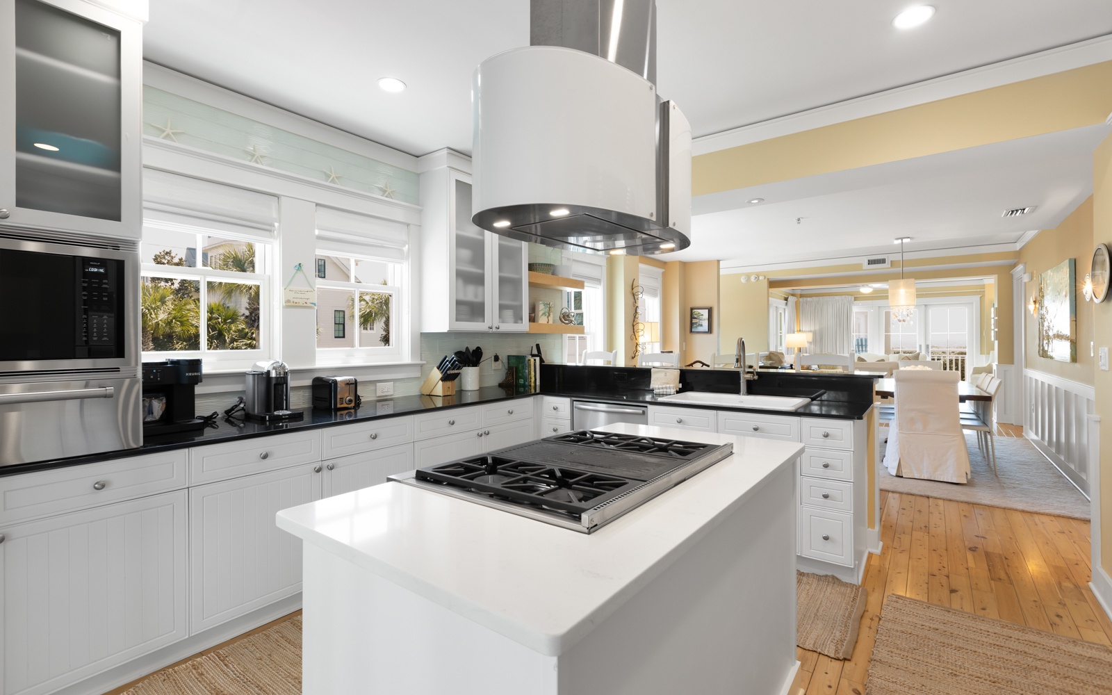 You'll love preparing meals in this stunning chef's kitchen, featuring premium appliances, elegant white cabinetry, and a spacious island perfect for cooking together.