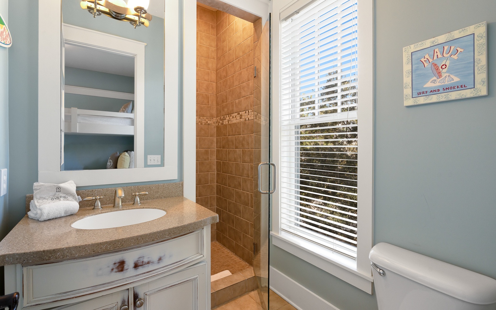 Your private bathroom features a walk-in shower with warm tile work, elegant vanity, and bright natural light for refreshing mornings.