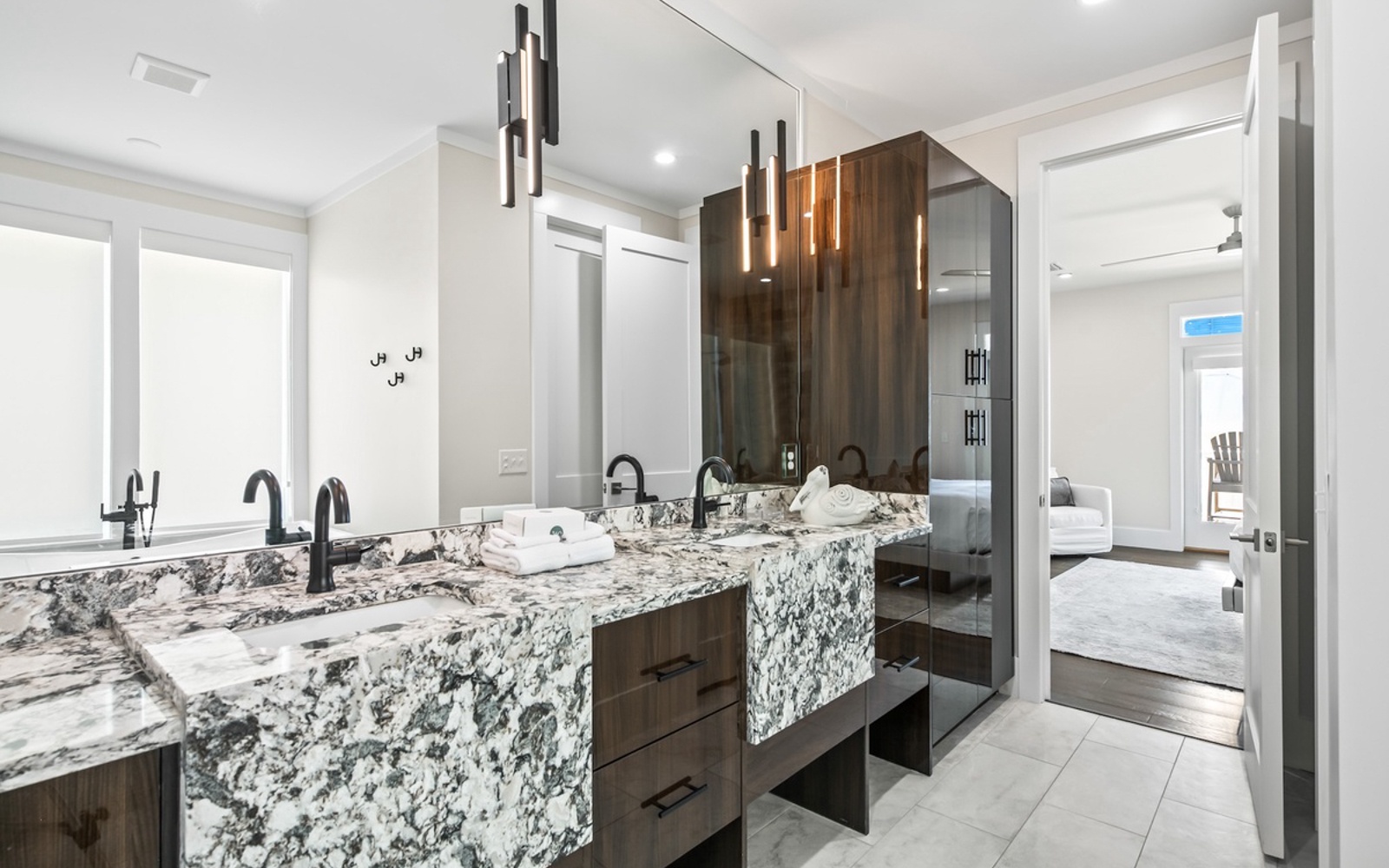 Indulge in your own marble-clad spa sanctuary, where elegant pendant lighting and dual vanities create the perfect space for your morning rituals.