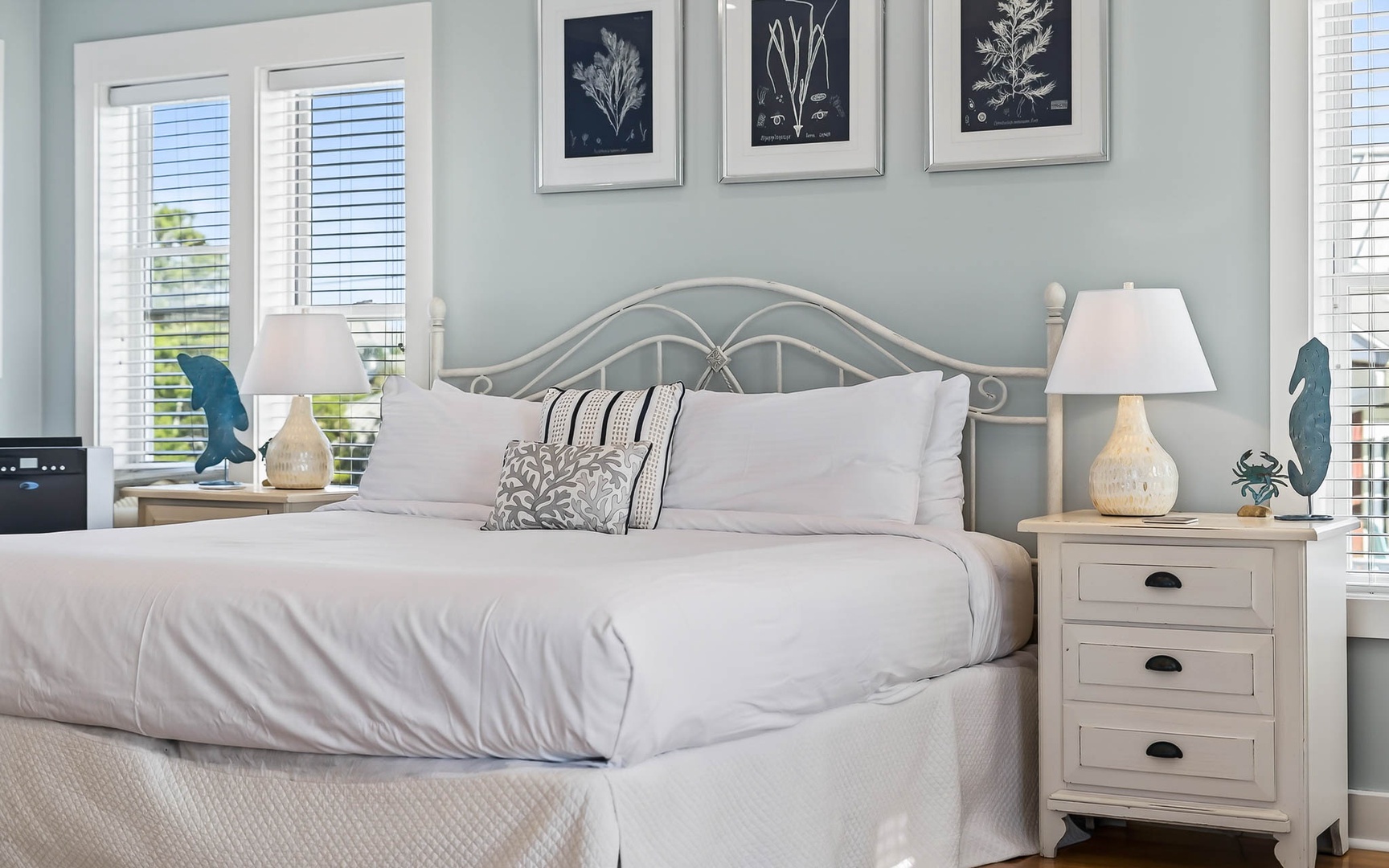 Drift off in your serene coastal retreat with crisp white linens and elegant botanical artwork creating the perfect peaceful sanctuary.