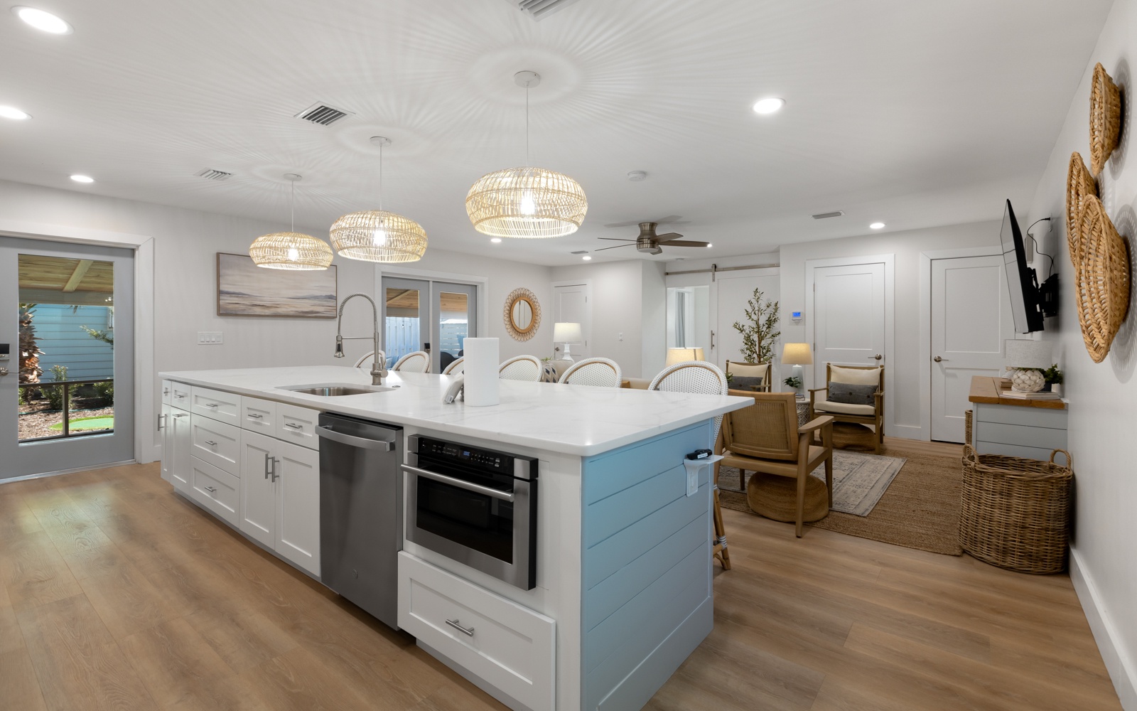 Gather around your spacious kitchen island where coastal pendant lights cast a warm glow over marble countertops, perfect for morning coffee or evening conversations.