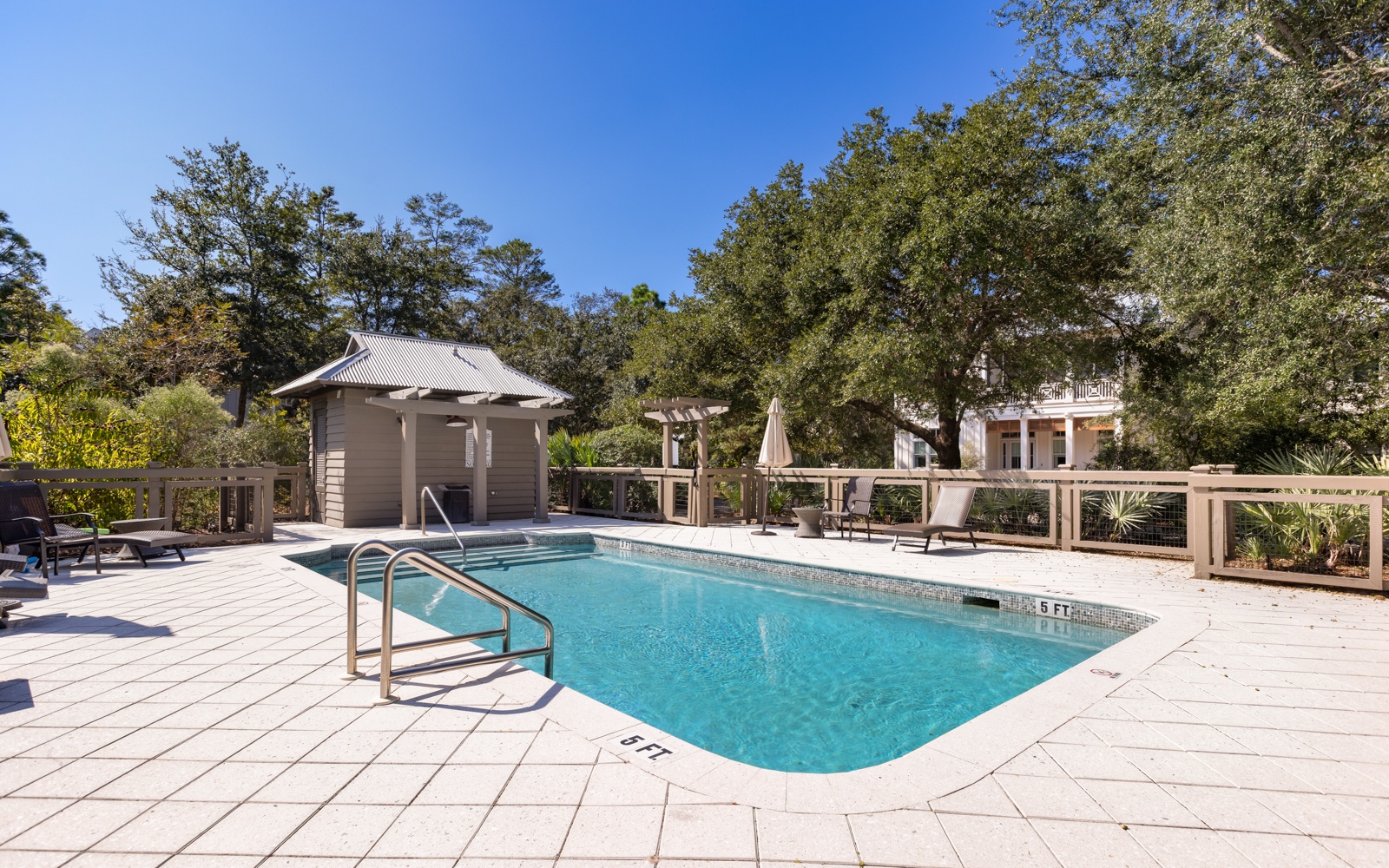 Dive into your private oasis with crystal-clear pool waters surrounded by lush trees and comfortable lounging areas.