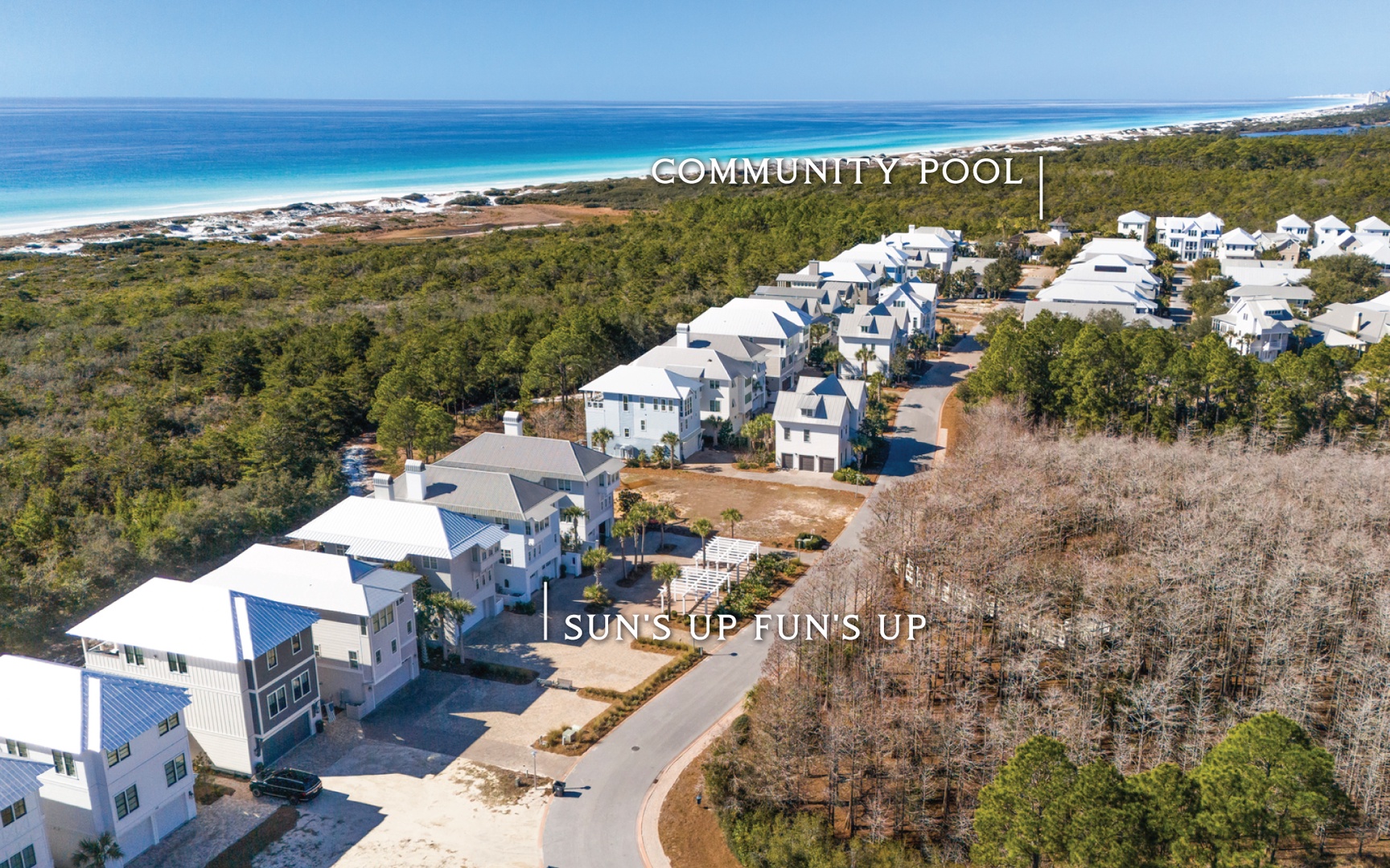 Stunning aerial view of vacation homes nestled between pristine white sand beaches and lush coastal vegetation.
