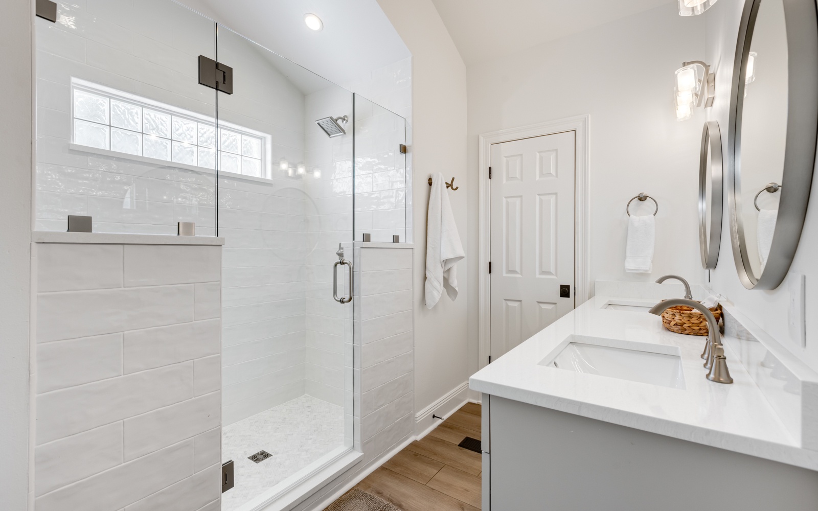 Your modern bathroom features a luxurious walk-in shower with marble tiles and a sleek vanity with dual mirrors for your morning routine.