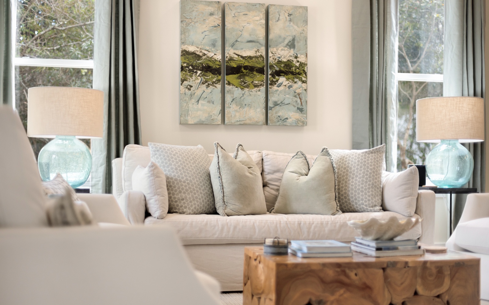 Sink into plush cushions in your serene living space, where soft blues and natural light create the perfect retreat for relaxation.