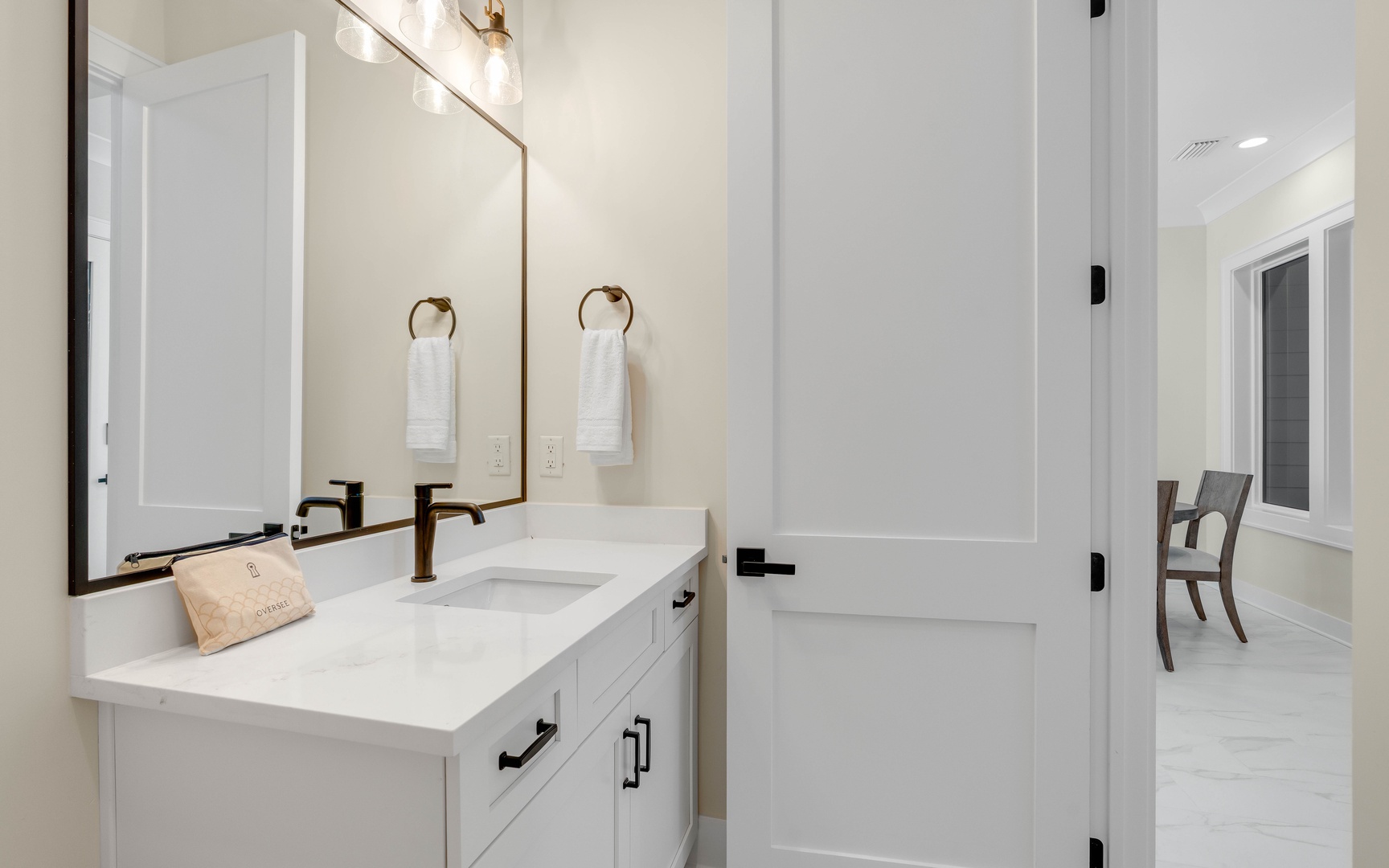 Your pristine bathroom features elegant marble countertops, warm brass fixtures, and fluffy towels waiting for your arrival.