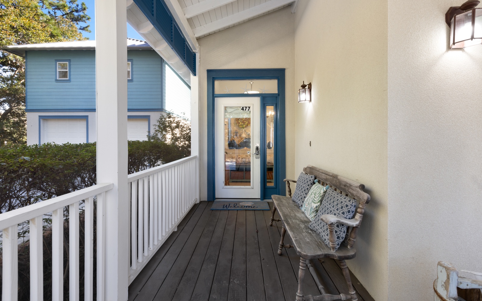 Charming front porch with coastal-style seating where you can unwind and watch the world go by in this welcoming neighborhood setting.