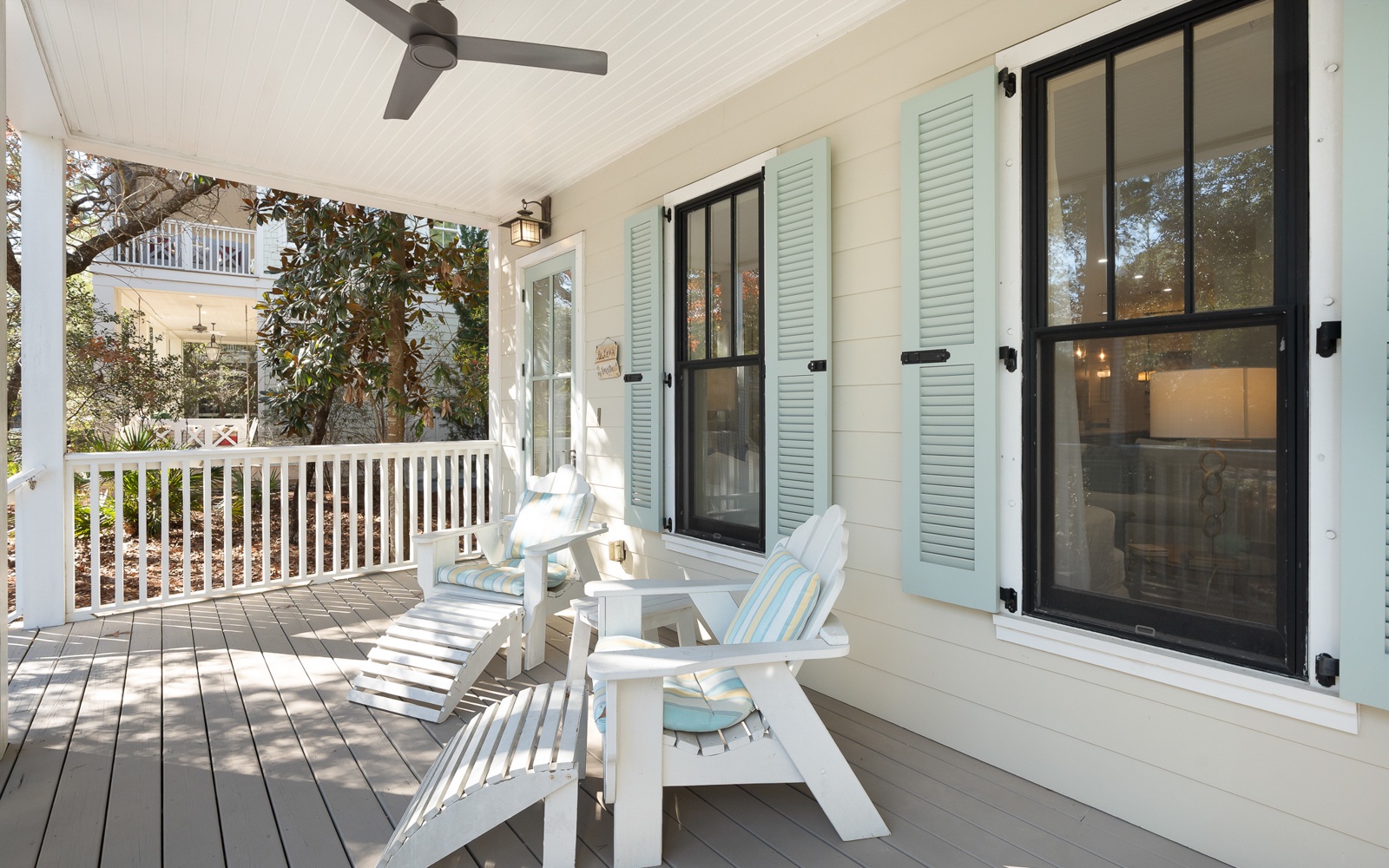 Unwind on your private covered porch with comfortable seating and gentle ceiling fan breezes creating the perfect coastal retreat.