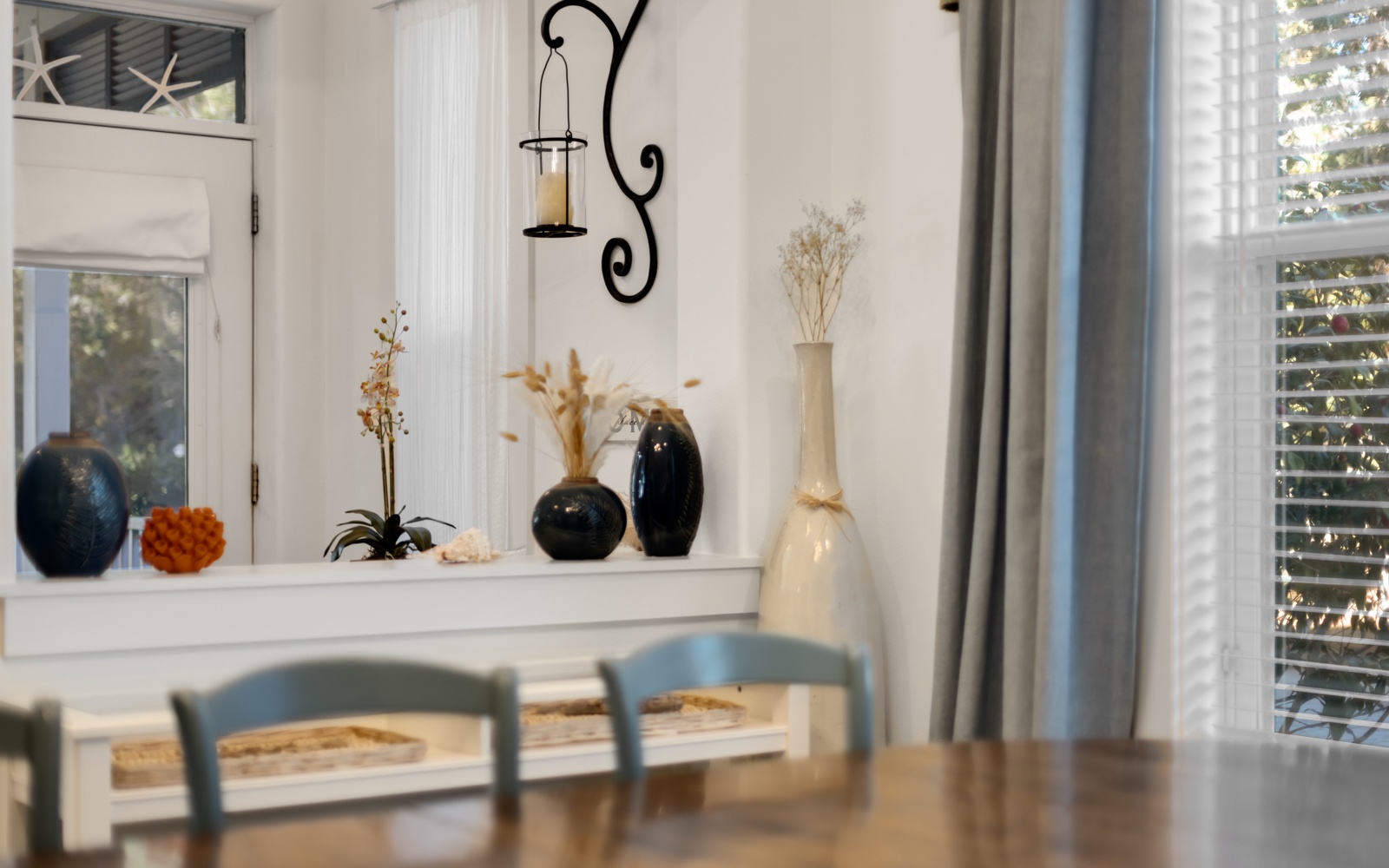 Gather around this inviting dining table, where thoughtful décor and warm natural light create the perfect atmosphere for shared meals.
