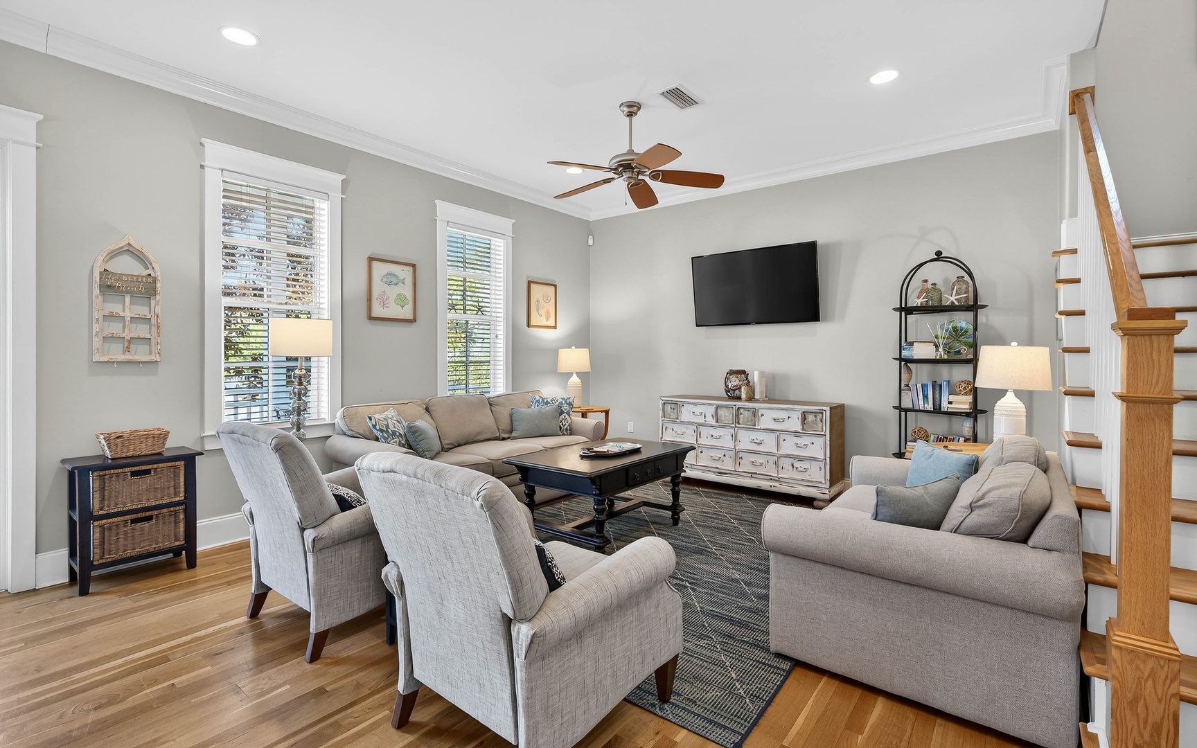 Relax in your spacious living room with comfortable seating, modern entertainment, and abundant natural light streaming through tall windows.