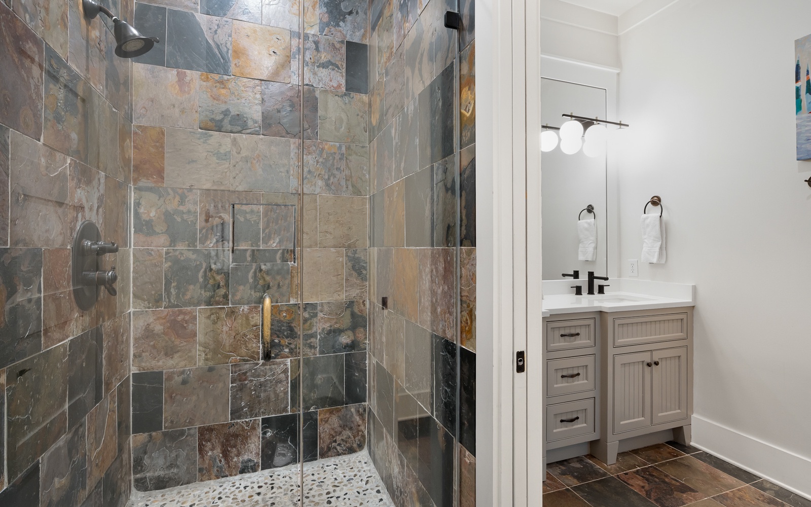 Step into your spa-like bathroom featuring a stunning stone-tiled shower with rainfall head and elegant vanity for your morning rituals.