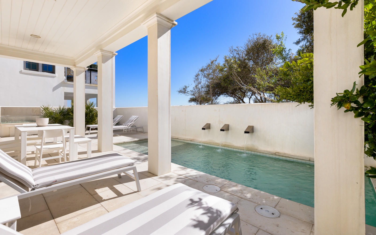 Relax poolside on your private terrace with crystal-clear water, elegant white loungers, and tropical views framing your perfect getaway.