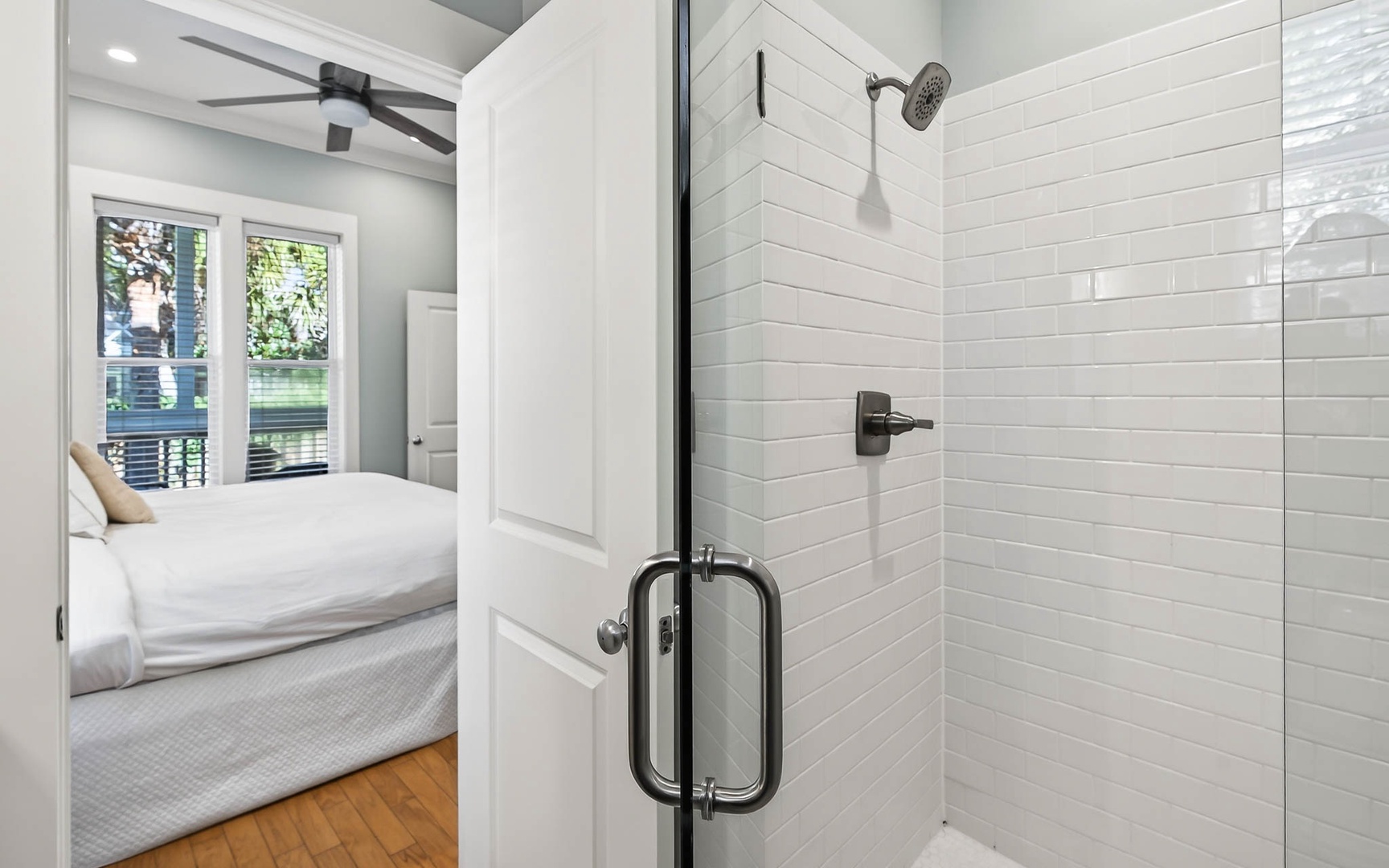 Unwind in your elegant ensuite with a sleek glass shower featuring white subway tiles and modern fixtures.