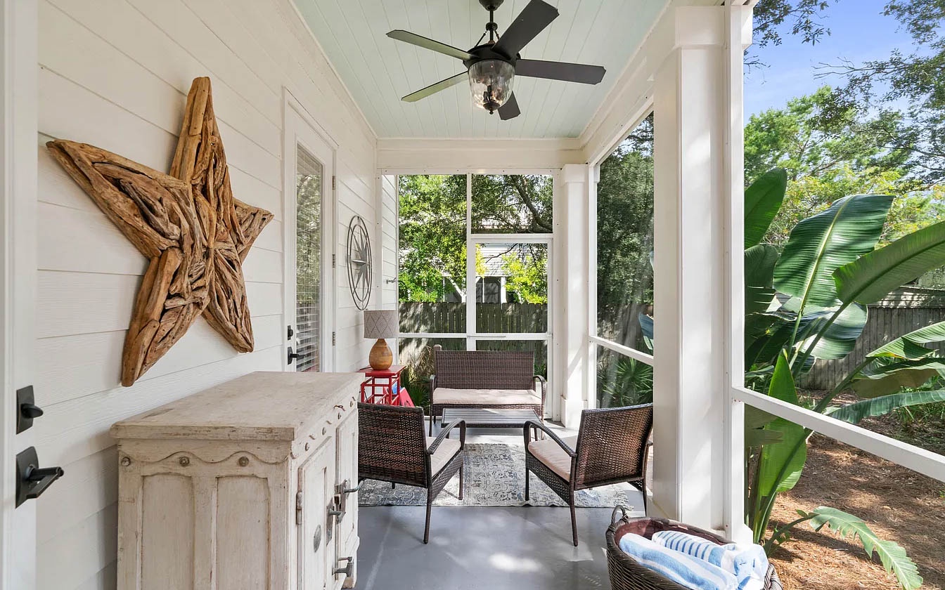 Unwind in your private screened porch with cozy seating and charming coastal decor, perfect for morning coffee or evening relaxation.
