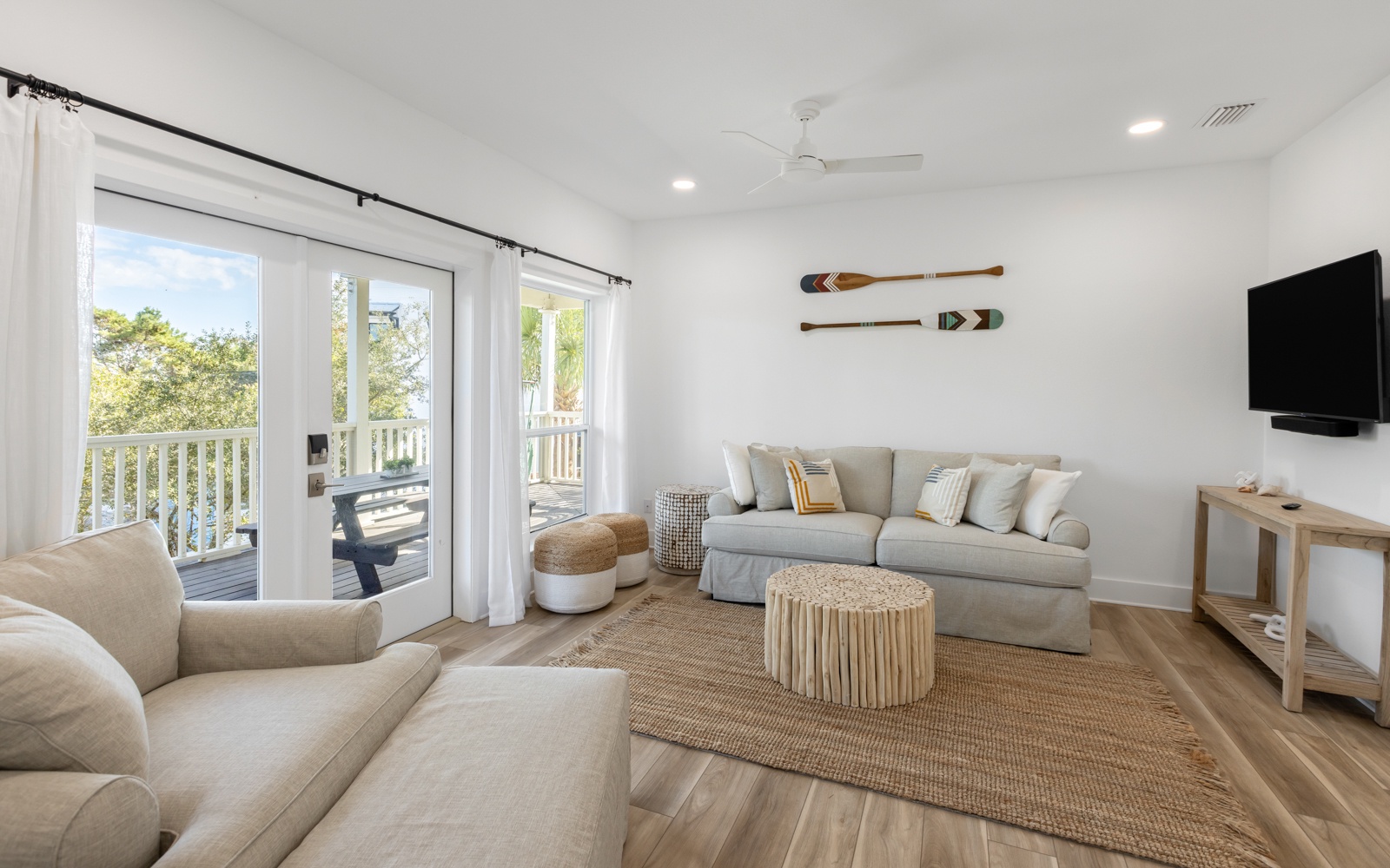 Unwind in your bright living room where coastal-inspired décor and large windows create a serene retreat perfect for relaxing after beach adventures.
