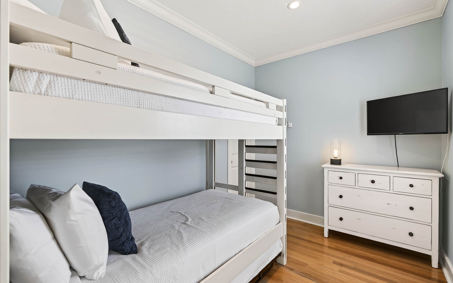 Your family will love this charming bunk room with soft linens, warm hardwood floors, and entertainment ready for cozy evenings together.