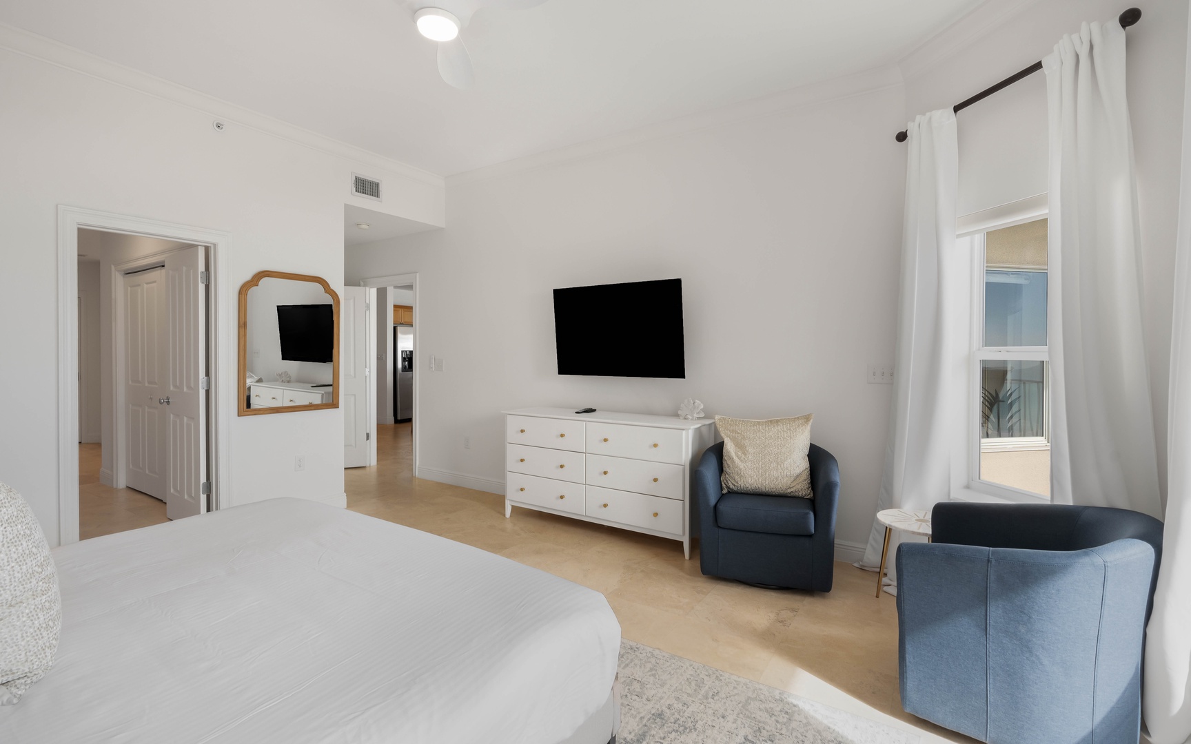 Unwind in your serene bedroom with plush seating, wall-mounted TV, and elegant furnishings that create the perfect retreat.