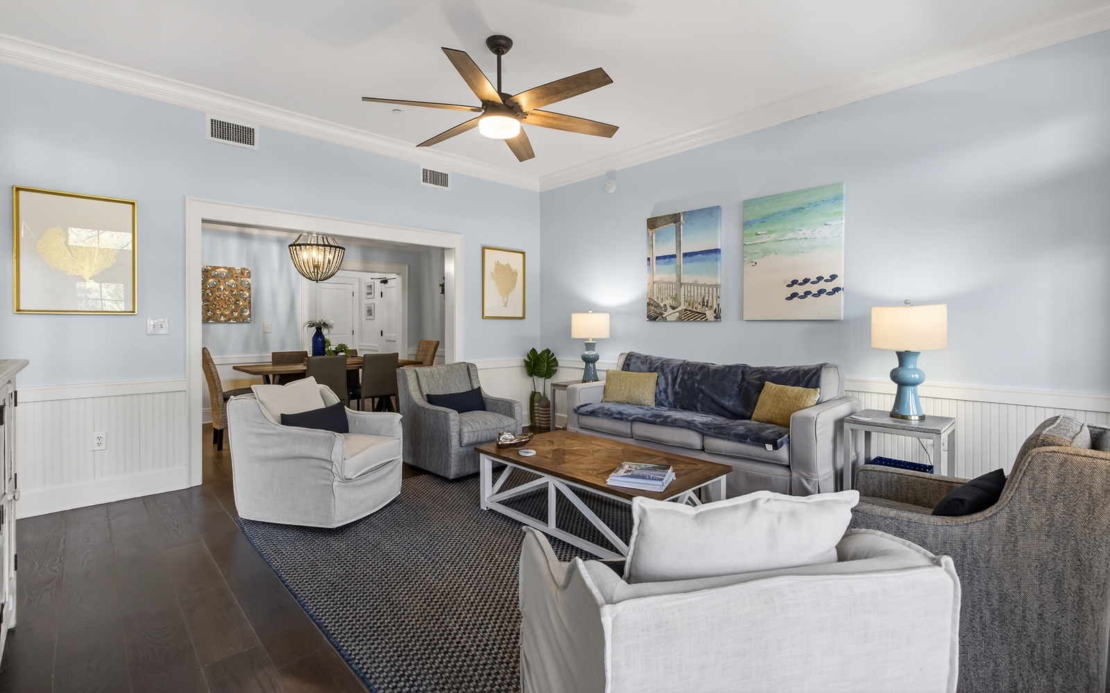 Unwind in your spacious coastal living room with plush seating and calming beach artwork that creates the perfect atmosphere for relaxation.