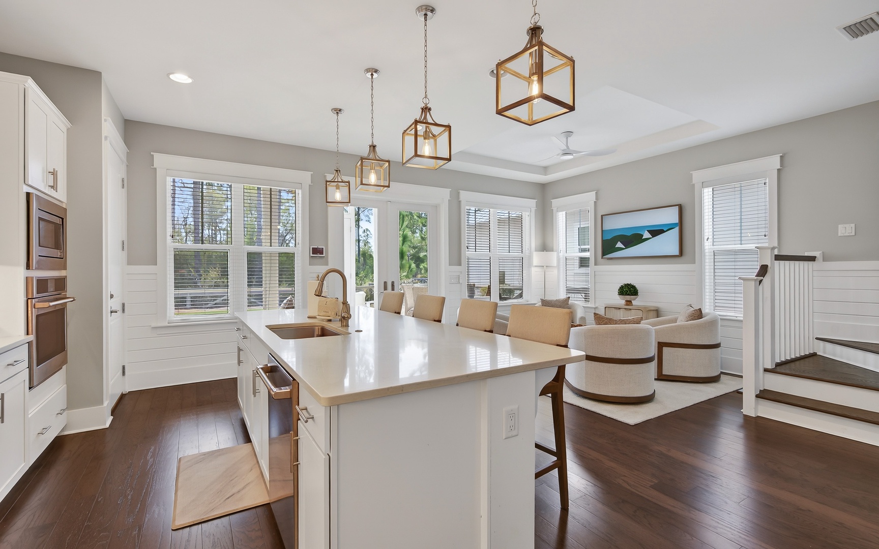 Gather around your stunning kitchen island while warm pendant lights illuminate shared meals and conversations in this open, airy space.