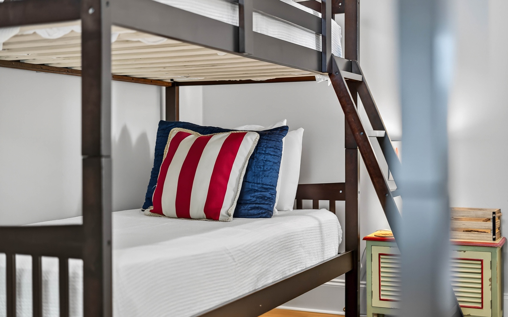 Rest easy in these cozy bunk beds with cheerful red and blue accents, perfect for your family adventure.