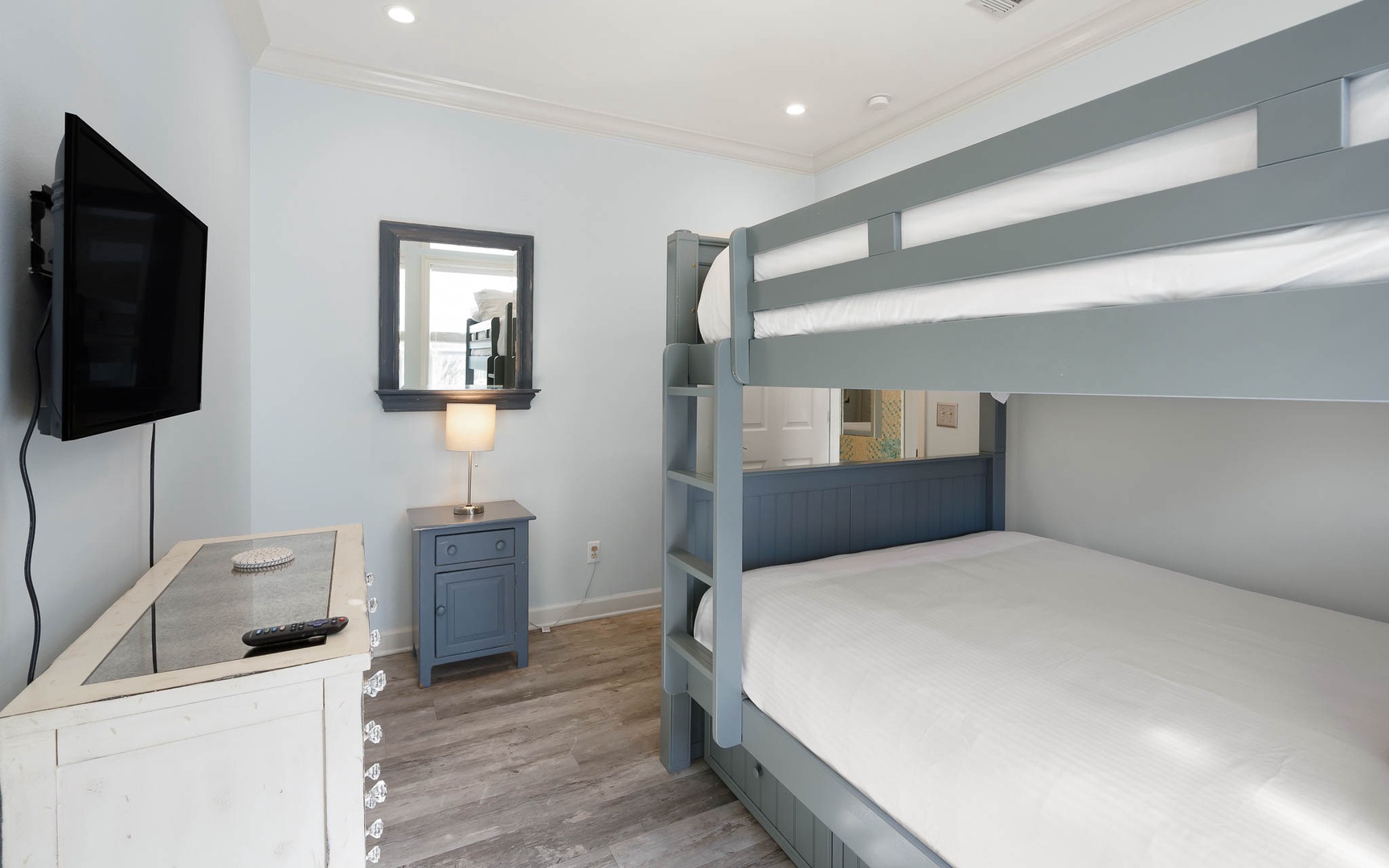 Cozy bunk room with charming blue beds, TV entertainment, and thoughtful touches for your perfect family getaway.