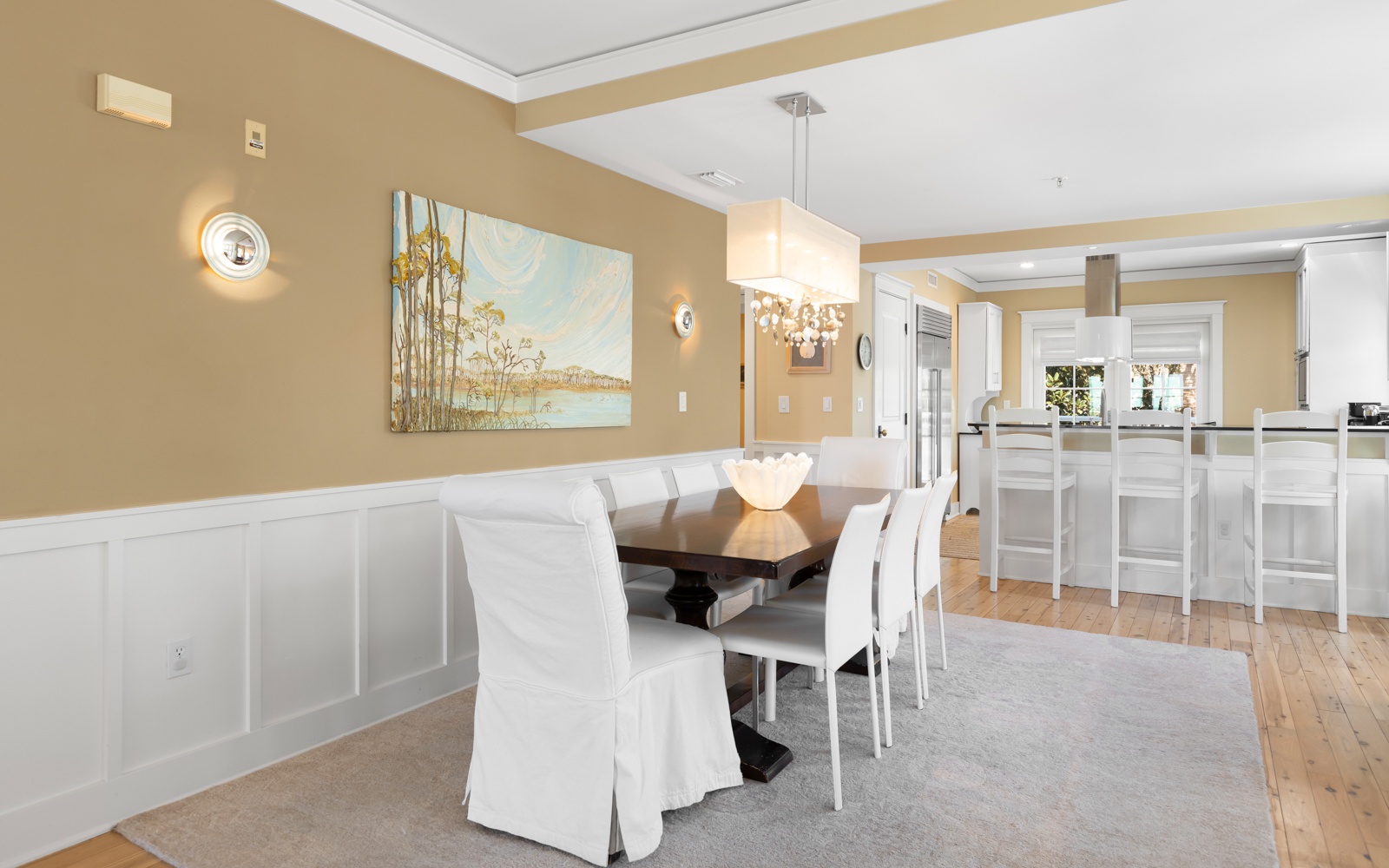 Gather around your elegant dining table for memorable meals in this sophisticated space with beautiful artwork and crystal chandelier.
