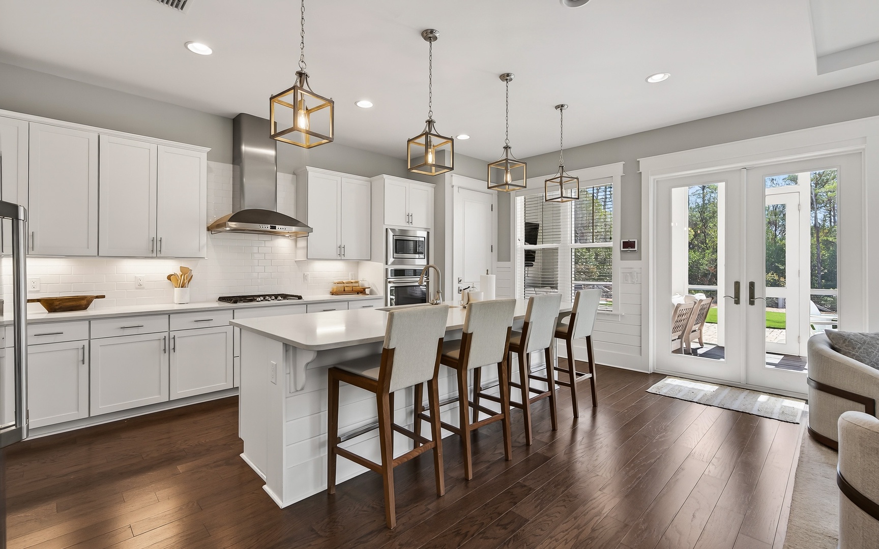 Your gourmet kitchen welcomes you with gleaming white cabinets, sleek countertops, and warm pendant lighting perfect for cooking memorable meals together.