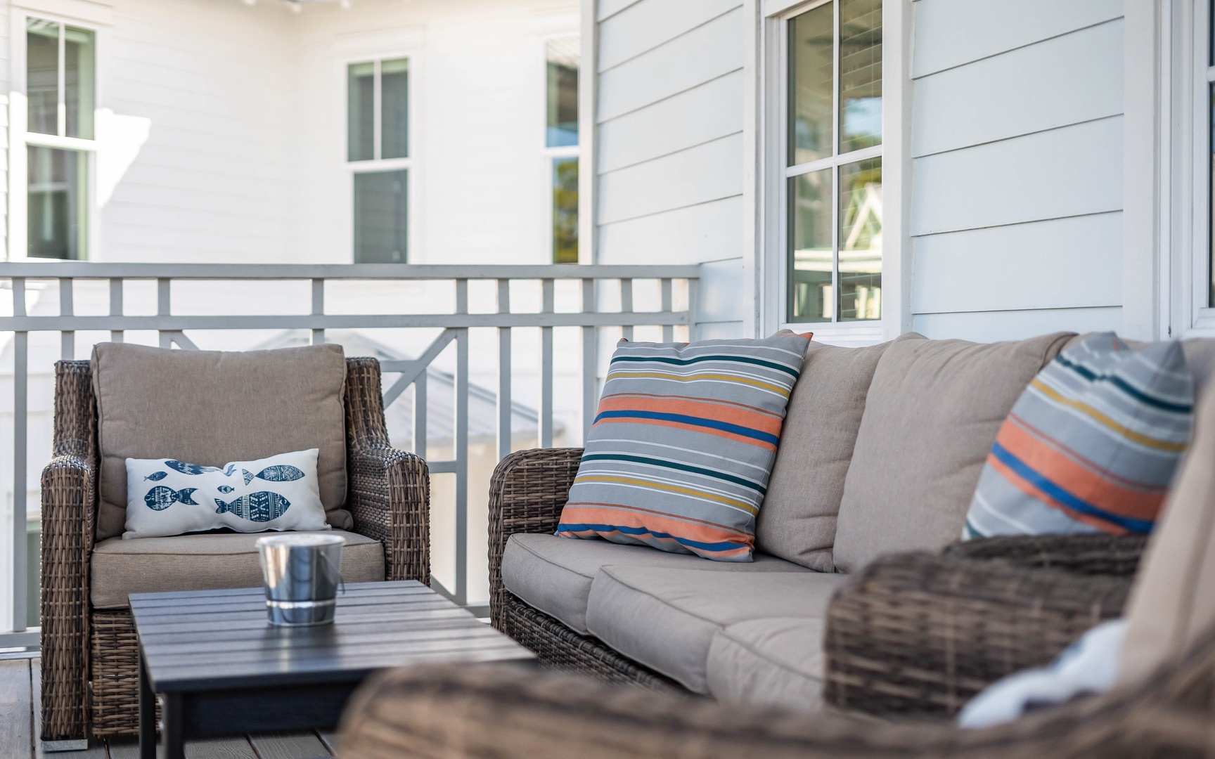 Step onto your private balcony and sink into plush wicker seating with colorful cushions, perfect for morning coffee or evening relaxation.