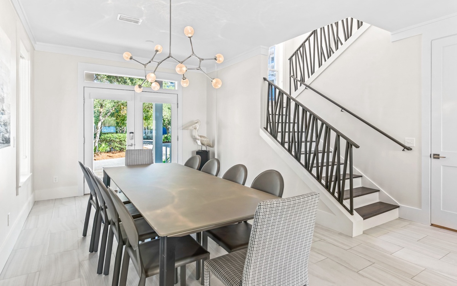 Gather around your sleek dining table for memorable meals under elegant statement lighting, with garden views beckoning beyond.