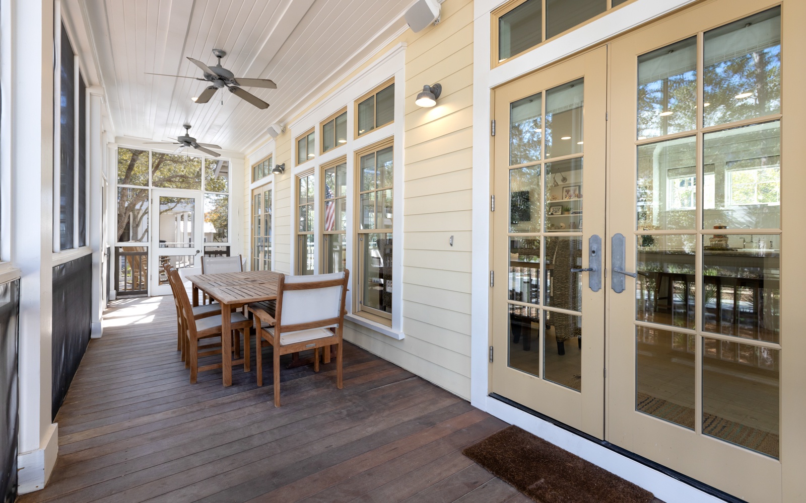 Step onto your covered porch where ceiling fans create gentle breezes as you dine al fresco at the wooden table.