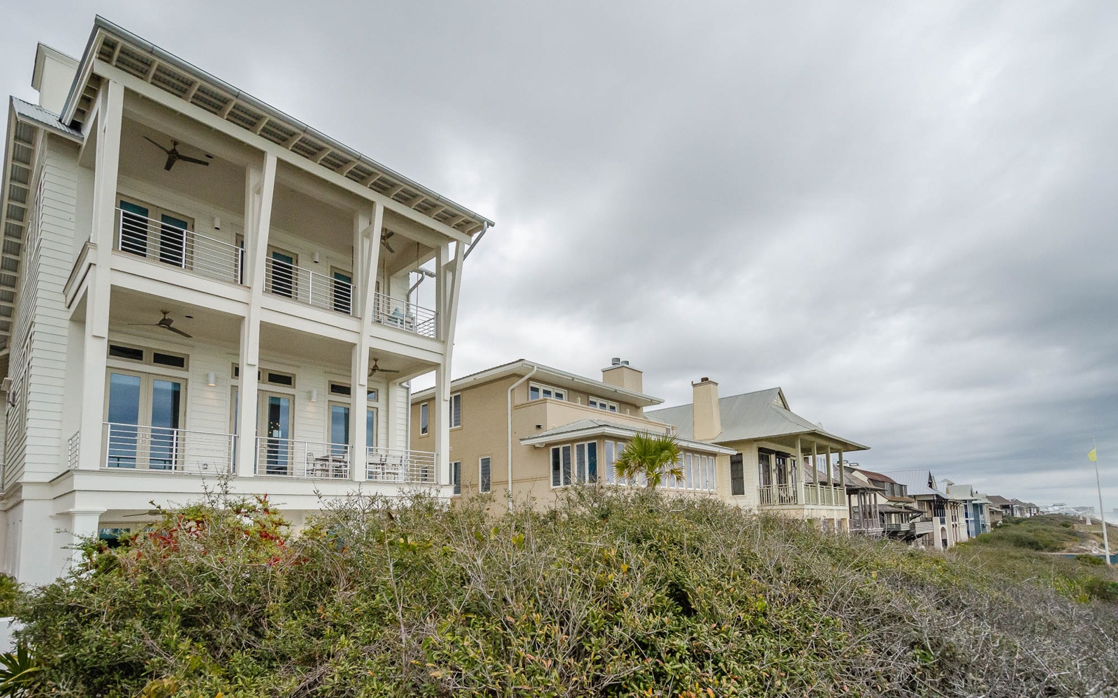 Stunning coastal architecture with covered porches and modern amenities in an exclusive beachfront neighborhood.