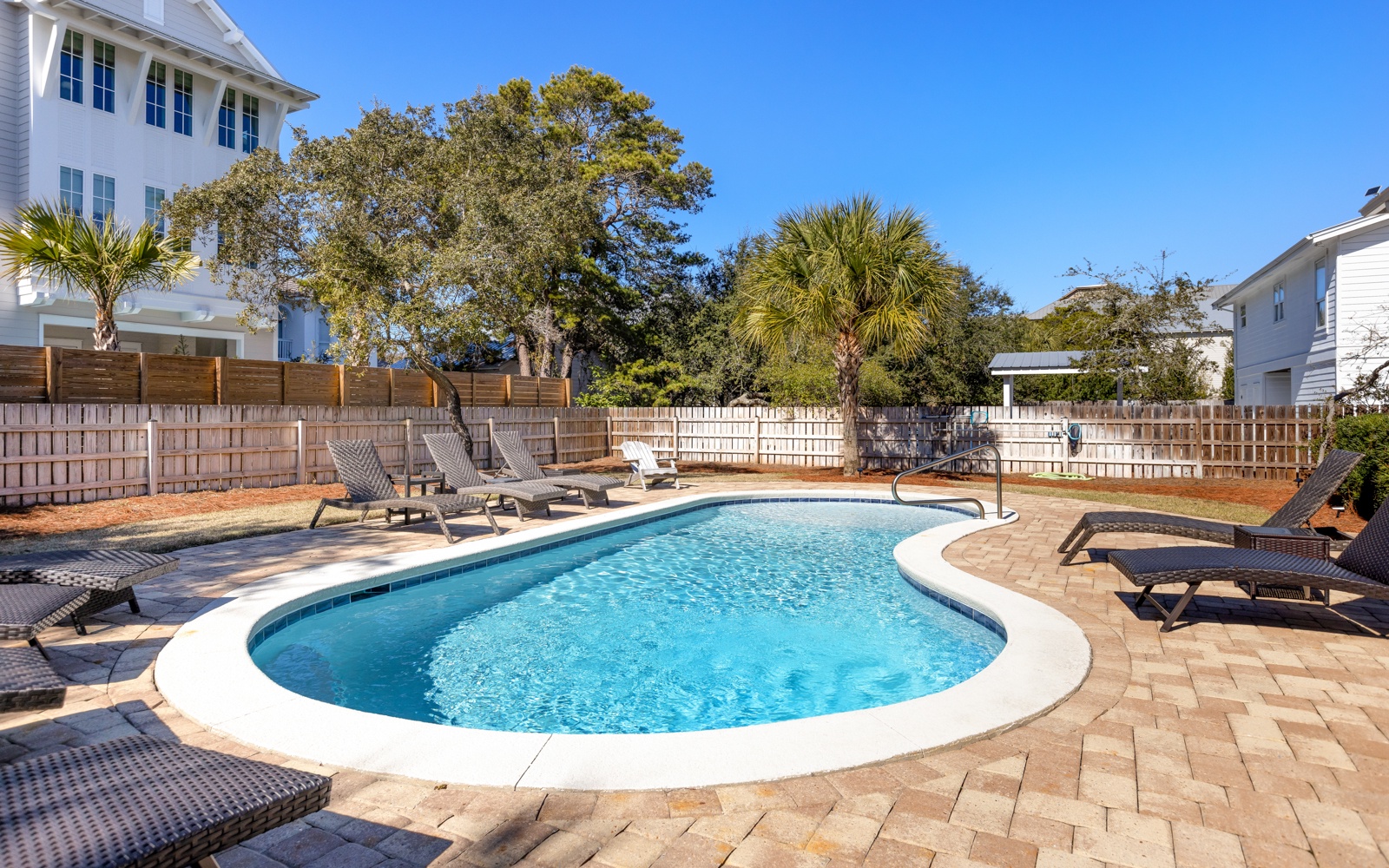 Dive into your private oasis featuring crystal-clear waters surrounded by comfortable loungers on elegant stone decking.