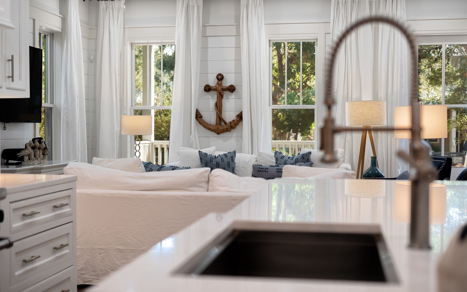 Your bright kitchen flows seamlessly into the cozy living space, where nautical charm meets modern comfort beneath soft natural light.