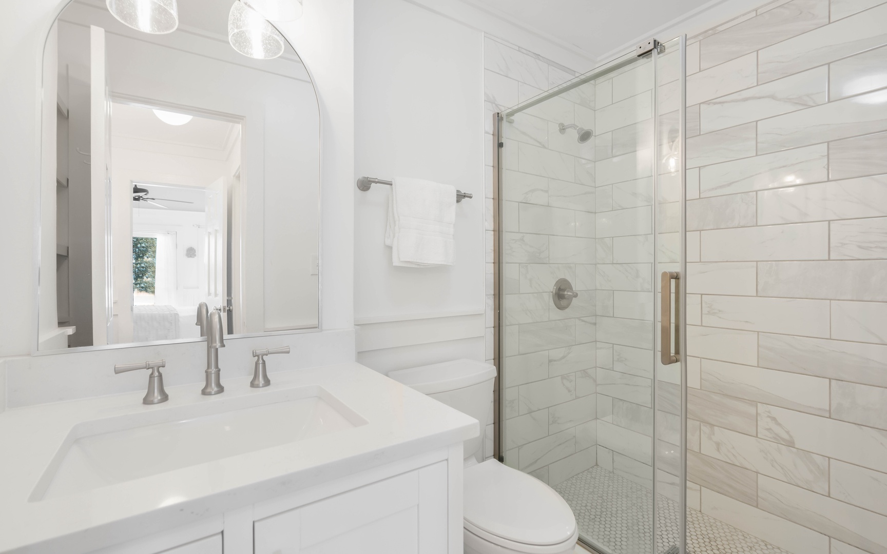 Step into your pristine marble bathroom with elegant subway tile and glass shower—a spa-like retreat for your morning routine.