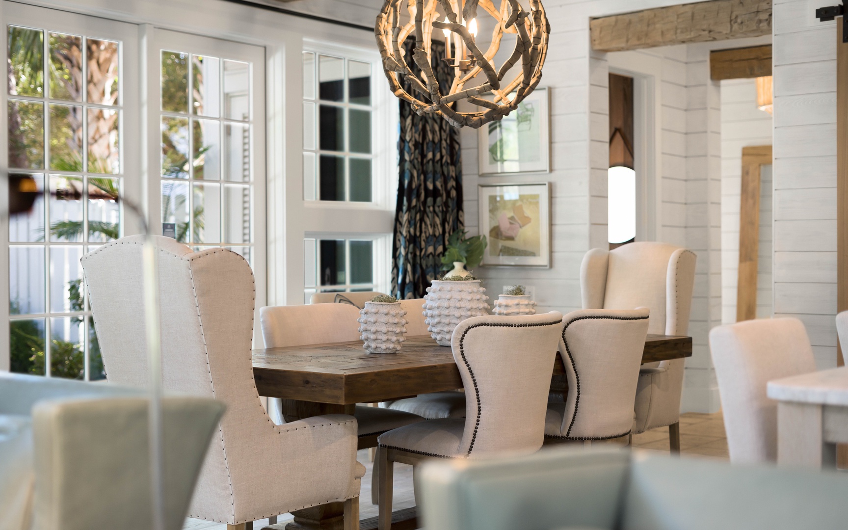 Gather around this elegant dining table where memorable meals await beneath warm lighting.