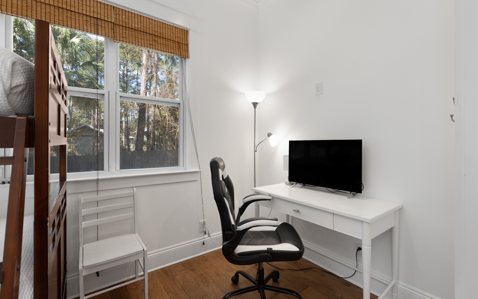 Your bright workspace features a sleek desk, comfortable chair, and TV - perfect for remote work with peaceful garden views.