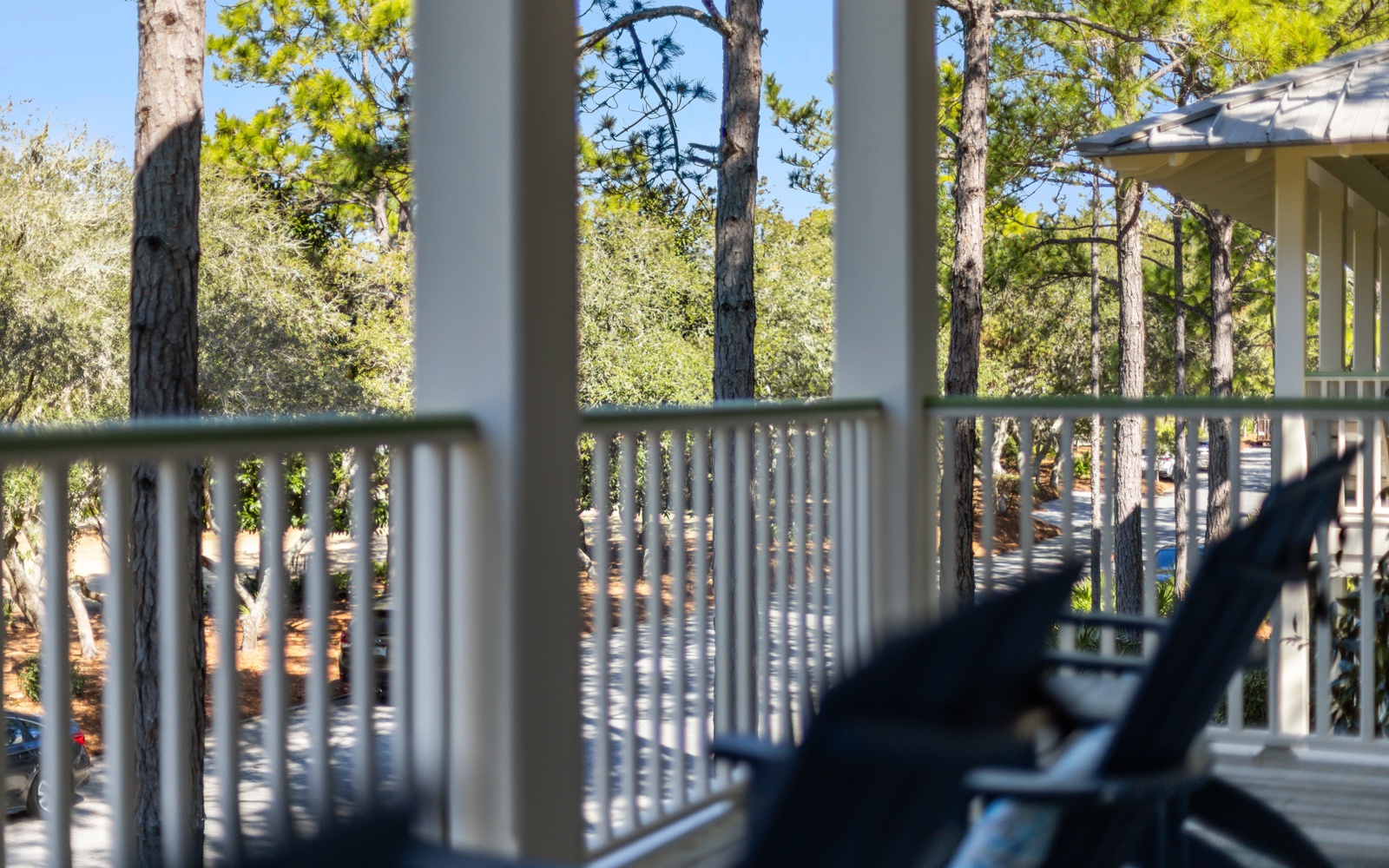 Relax on your private balcony surrounded by towering pine trees, where dappled sunlight creates the perfect retreat for your morning coffee.