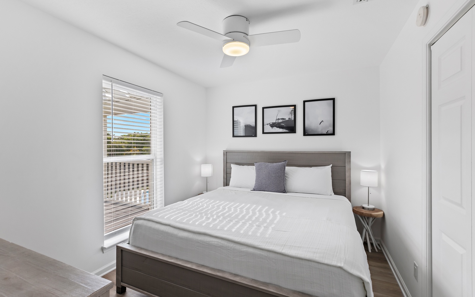 Drift off in your serene bedroom featuring crisp linens, a gentle ceiling fan, and natural light streaming through blinds.