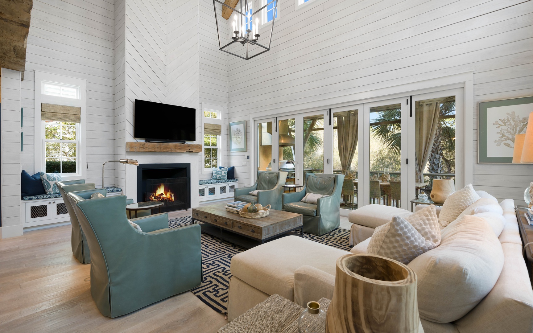 Unwind in your spacious living room with cozy fireplace, flat-screen TV, and elegant coastal furnishings perfect for relaxing evenings.