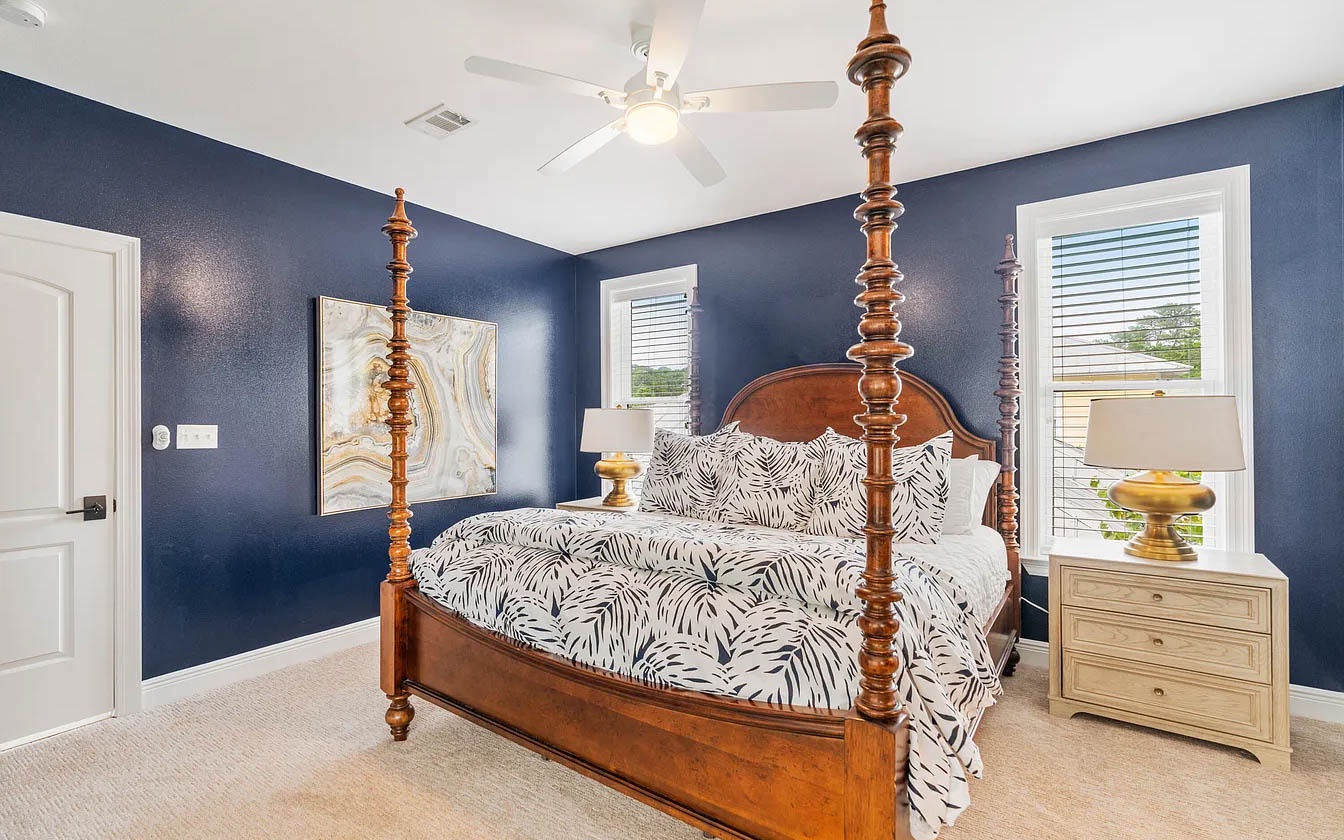 Drift into dreams in this elegant four-poster bed, wrapped in rich navy walls and tropical linens that create your perfect coastal retreat.