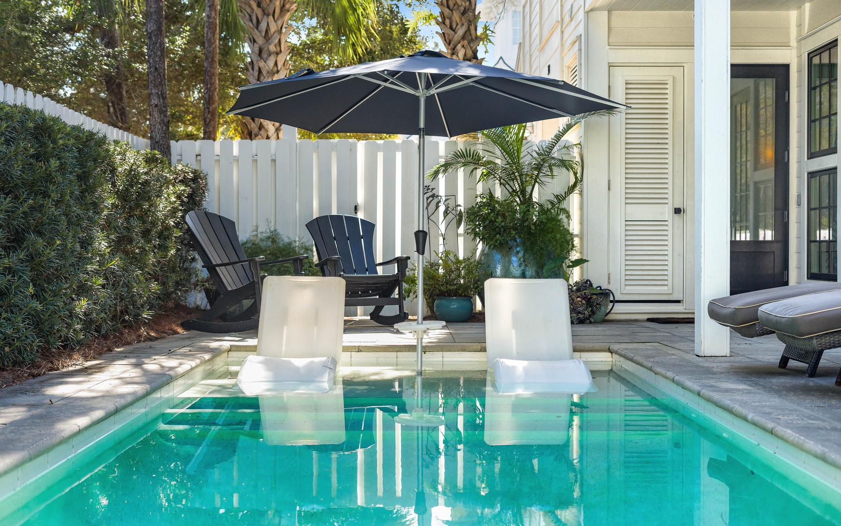 Your private pool oasis awaits with elegant in-water seating and shaded patio loungers, perfect for cooling off or soaking up the sun.