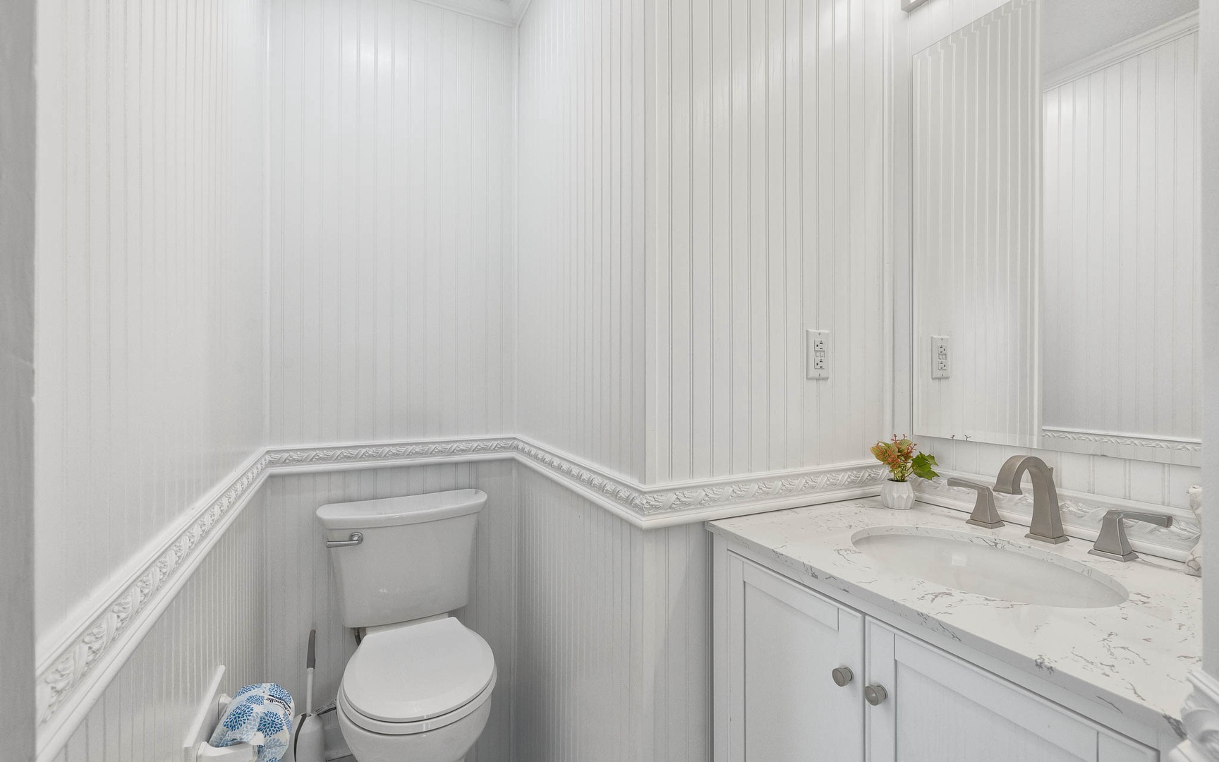 Your elegant powder room features classic wainscoting and marble countertops, creating a refined space for freshening up during your stay.