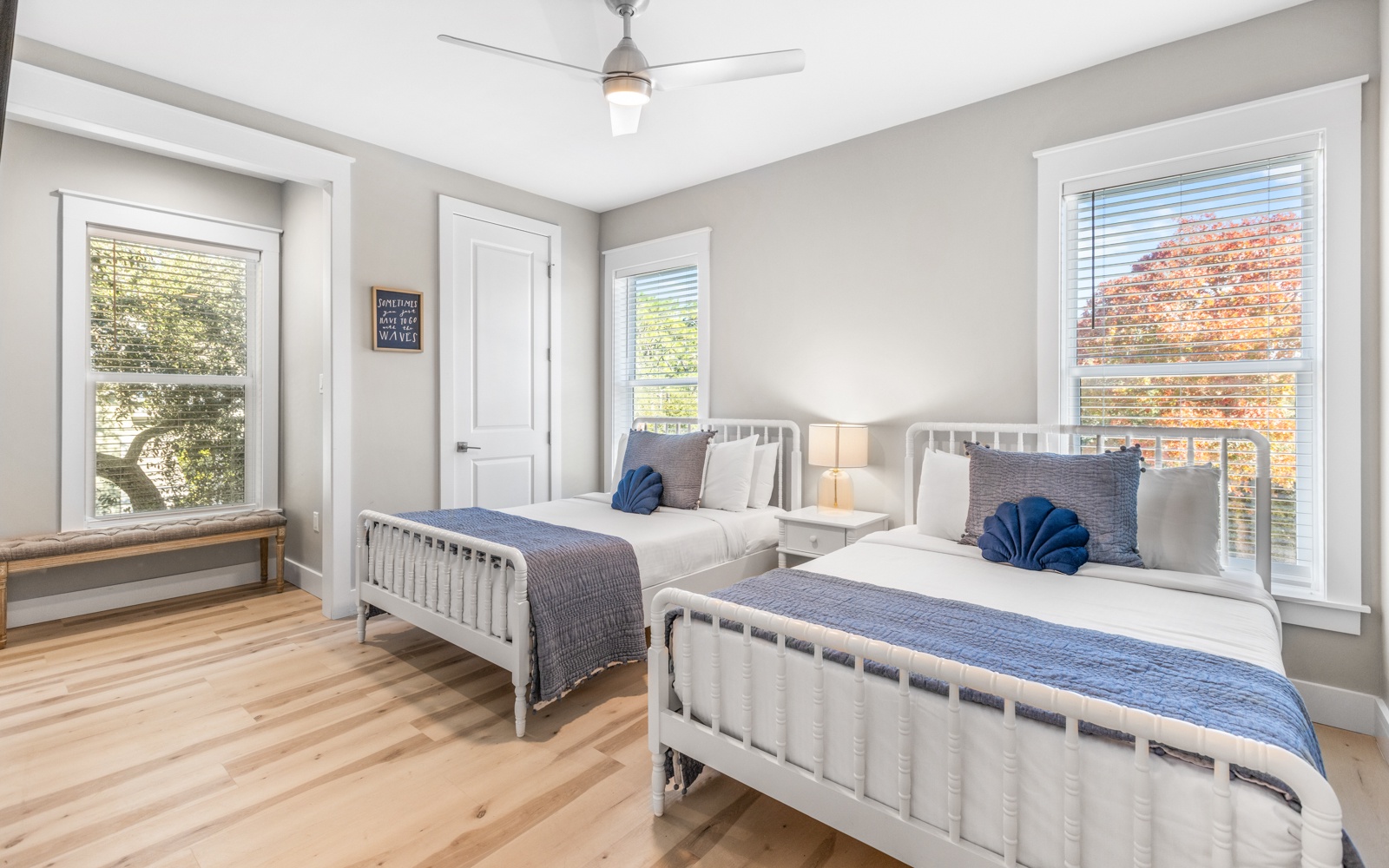 Rest peacefully in your bright twin bedroom with cozy blue accents and windows overlooking autumn trees.