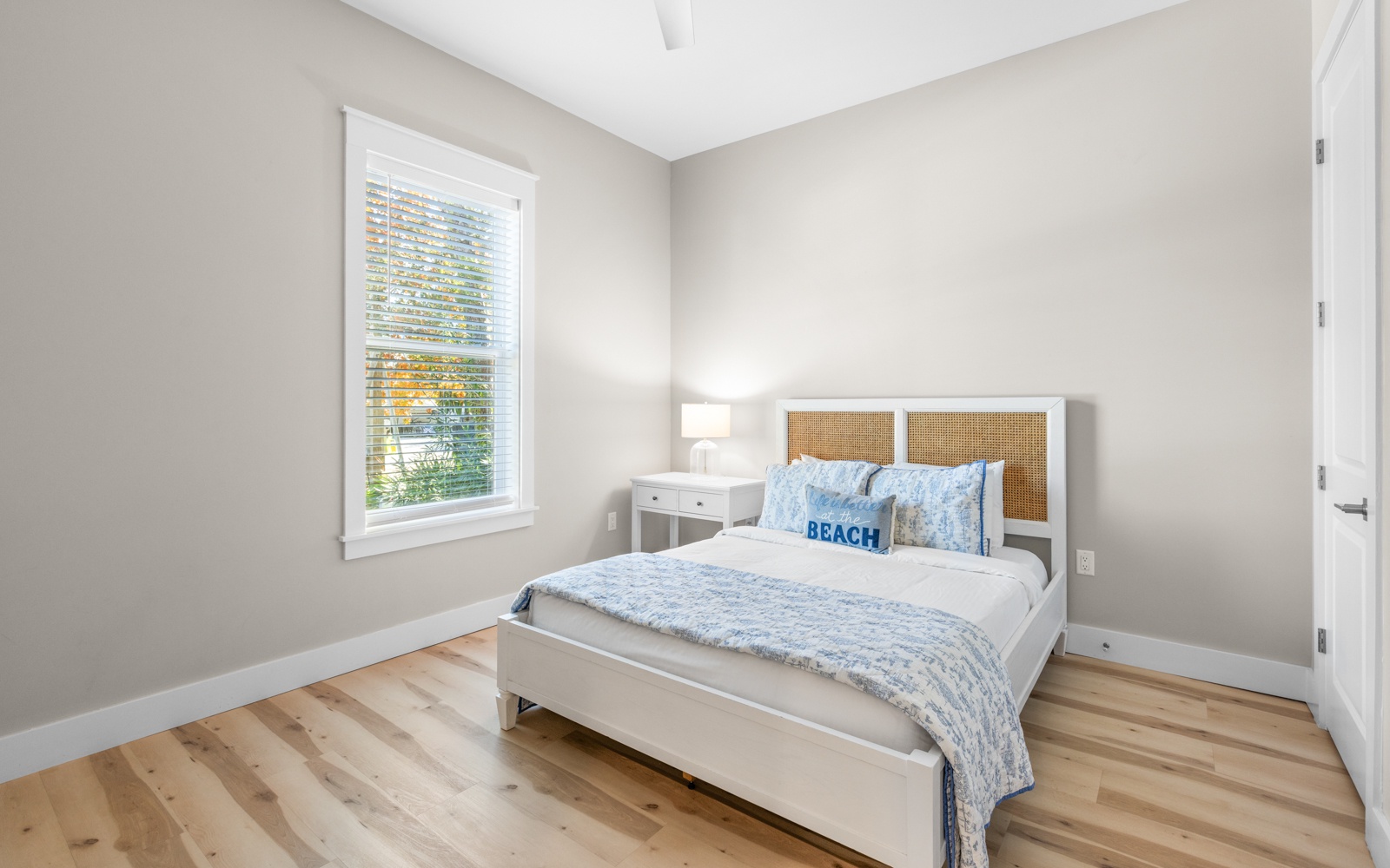 Wake up refreshed in your serene bedroom with natural light streaming through the window and soft coastal touches.