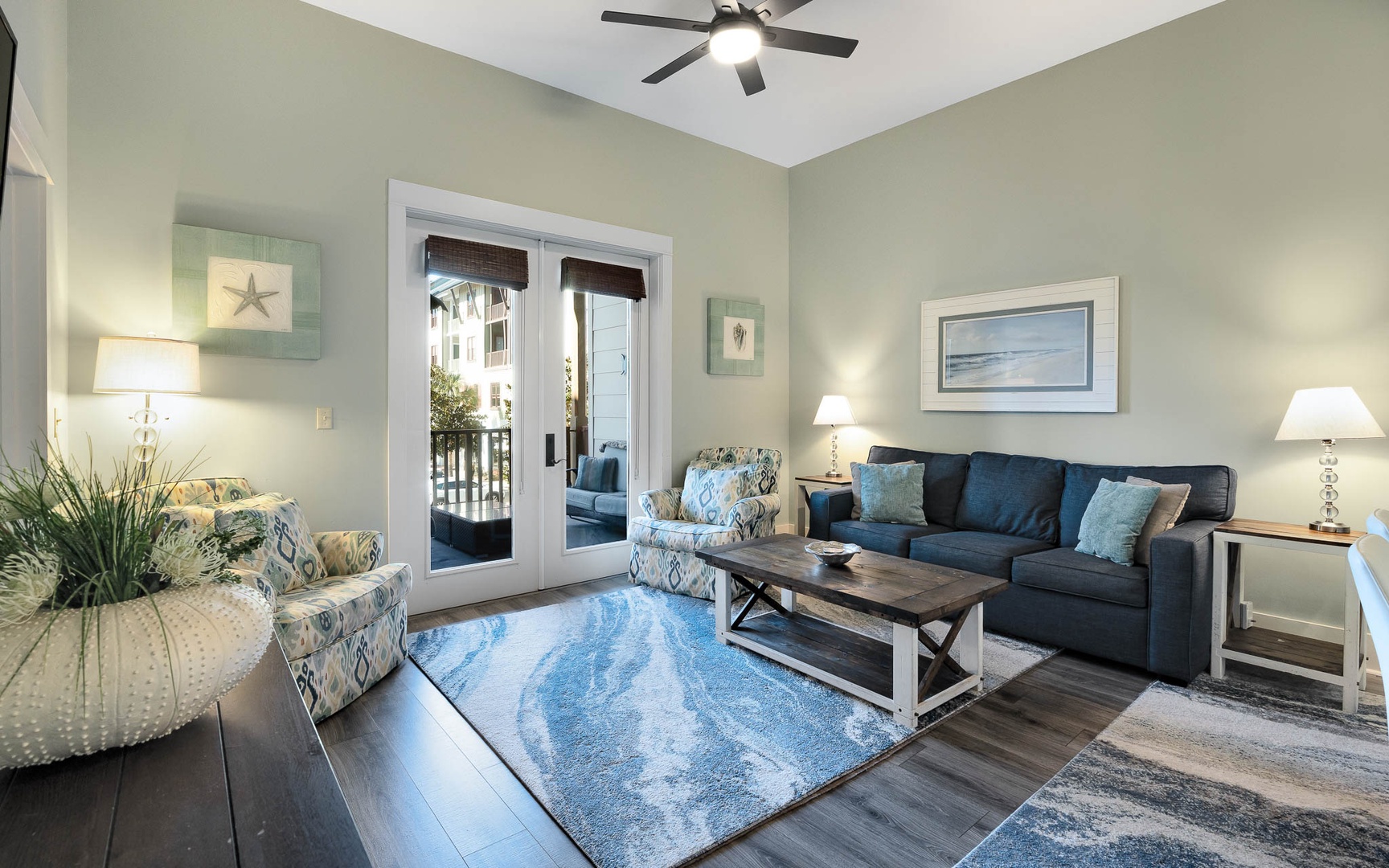 Sink into comfortable coastal-inspired furnishings while ocean breezes flow through your private balcony doors in this serene living space.