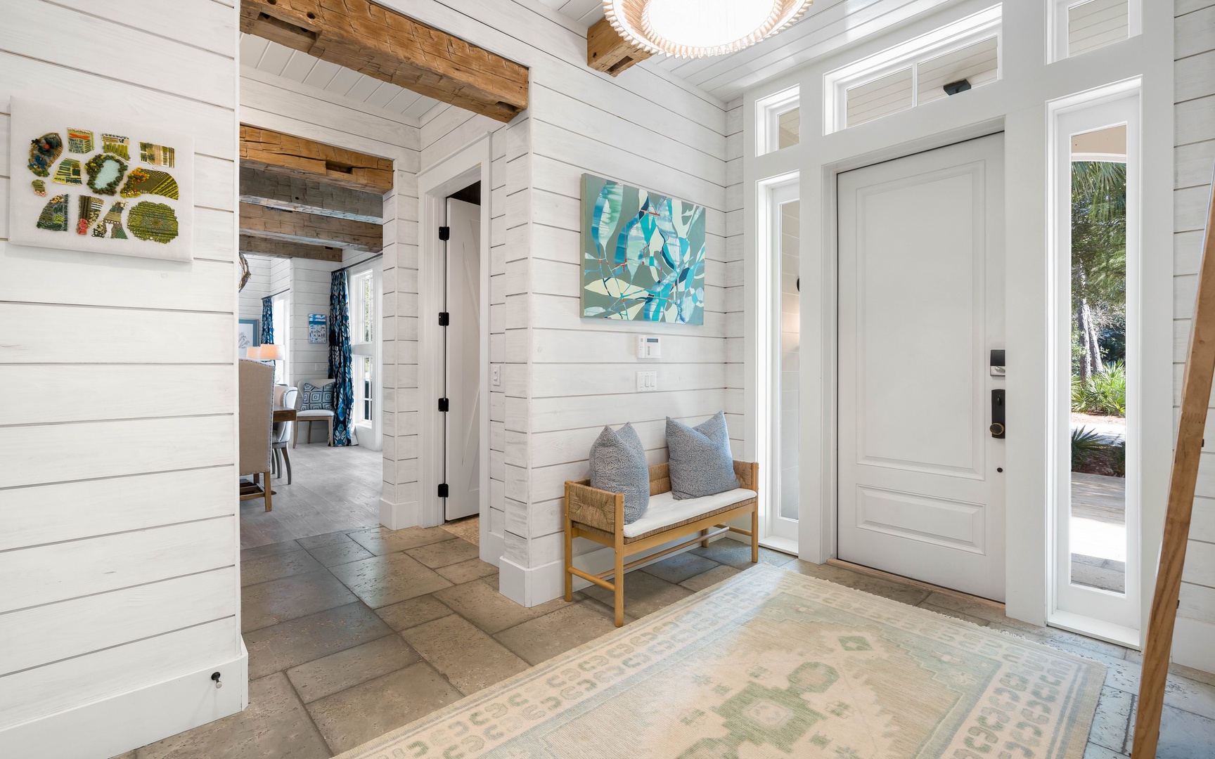 Step into your bright coastal retreat where white shiplap walls and warm wood beams create the perfect welcoming atmosphere for your stay.