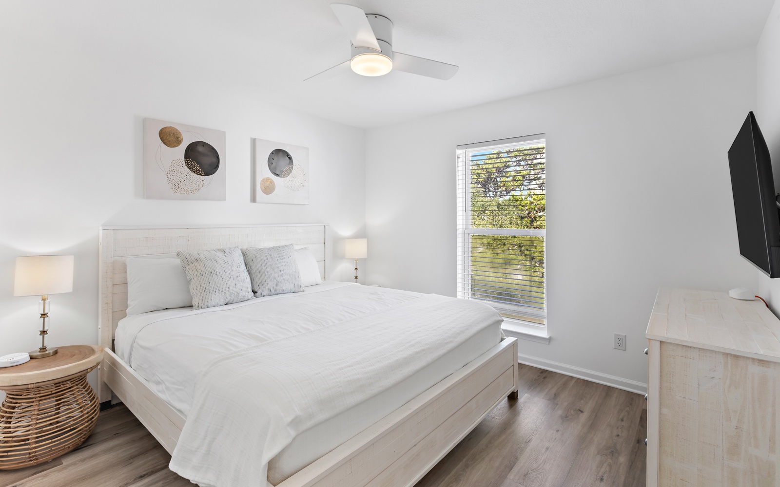 Sink into soft linens and wake refreshed in your serene bedroom, where natural light streams through windows overlooking lush greenery.